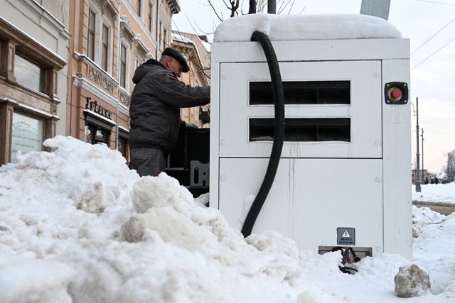 <p>An employee refuels a power generator outside a shop during a scheduled power outage in the centre of Lviv, following Russian missile and drone attacks on Ukrainian energy infrastructure</p>