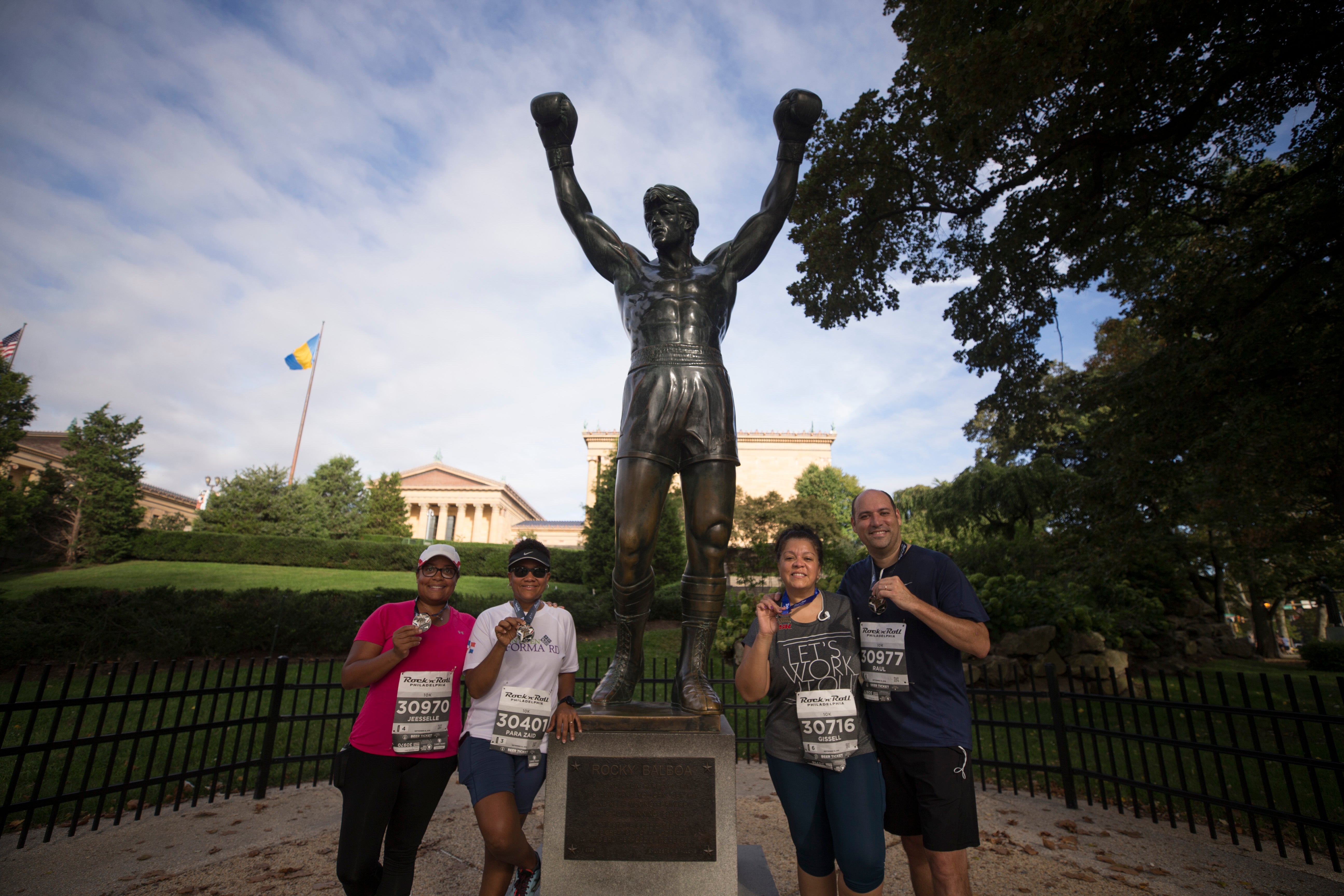 Runners pose for a picture in front of the Rocky statue in 2018. The statue is set to move to the top of the steps outside the Philadelphia Art Museum later this year