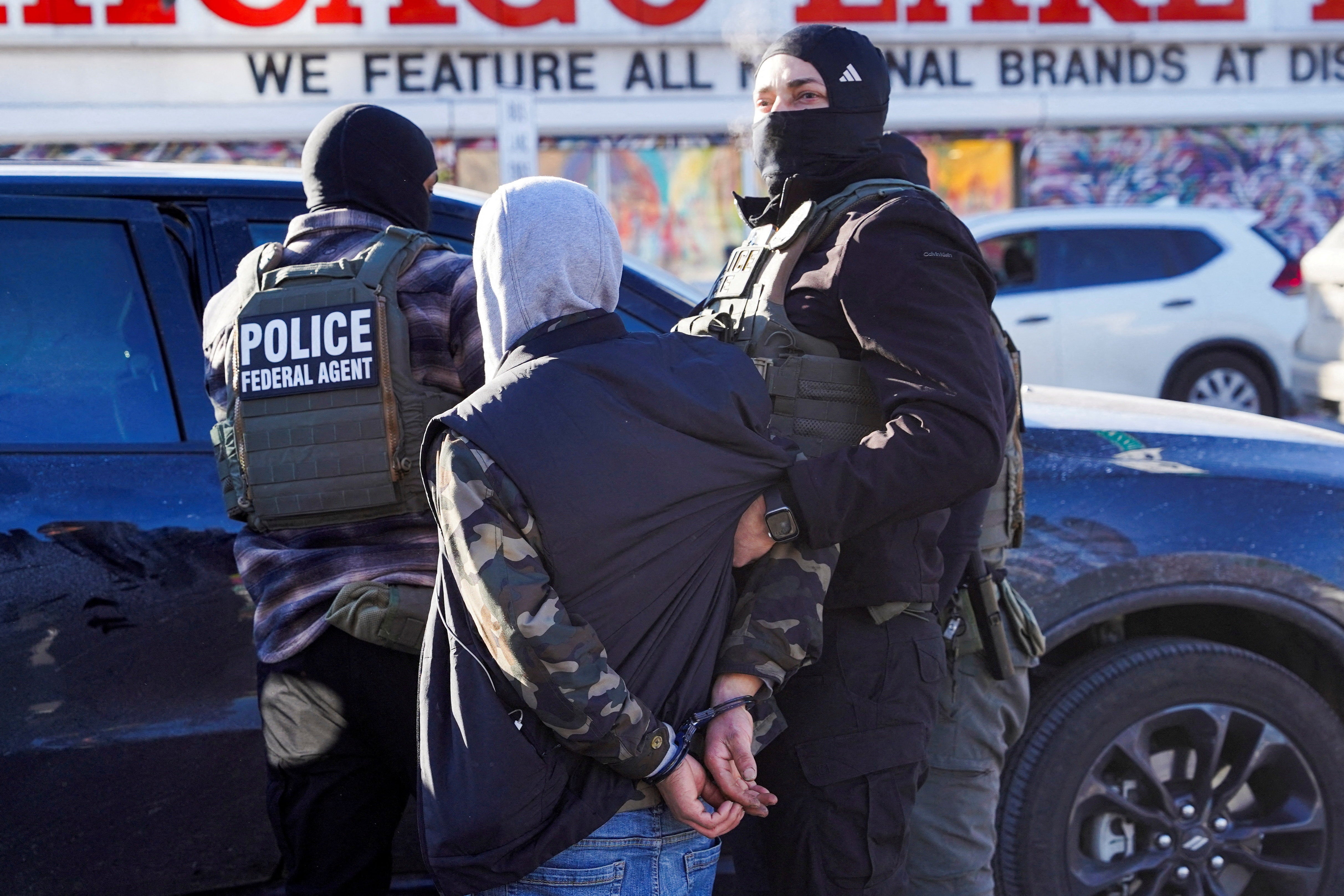 <p>Federal agents detain a person at a bus stop in Minneapolis on January 14</p>