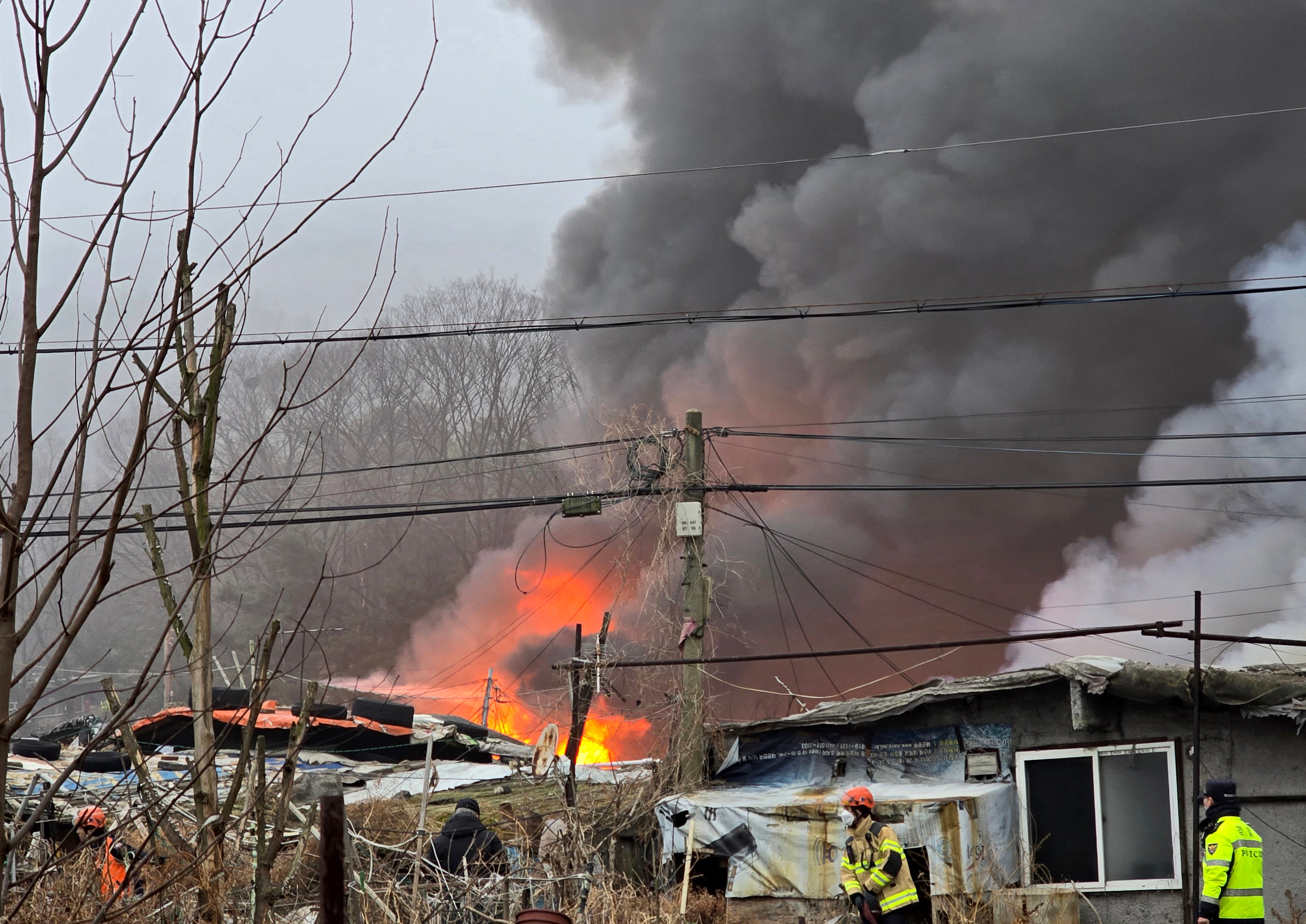 Firefighters battle a fire in the Guryong village shantytown, Seoul's largest informal settlement, in Seoul