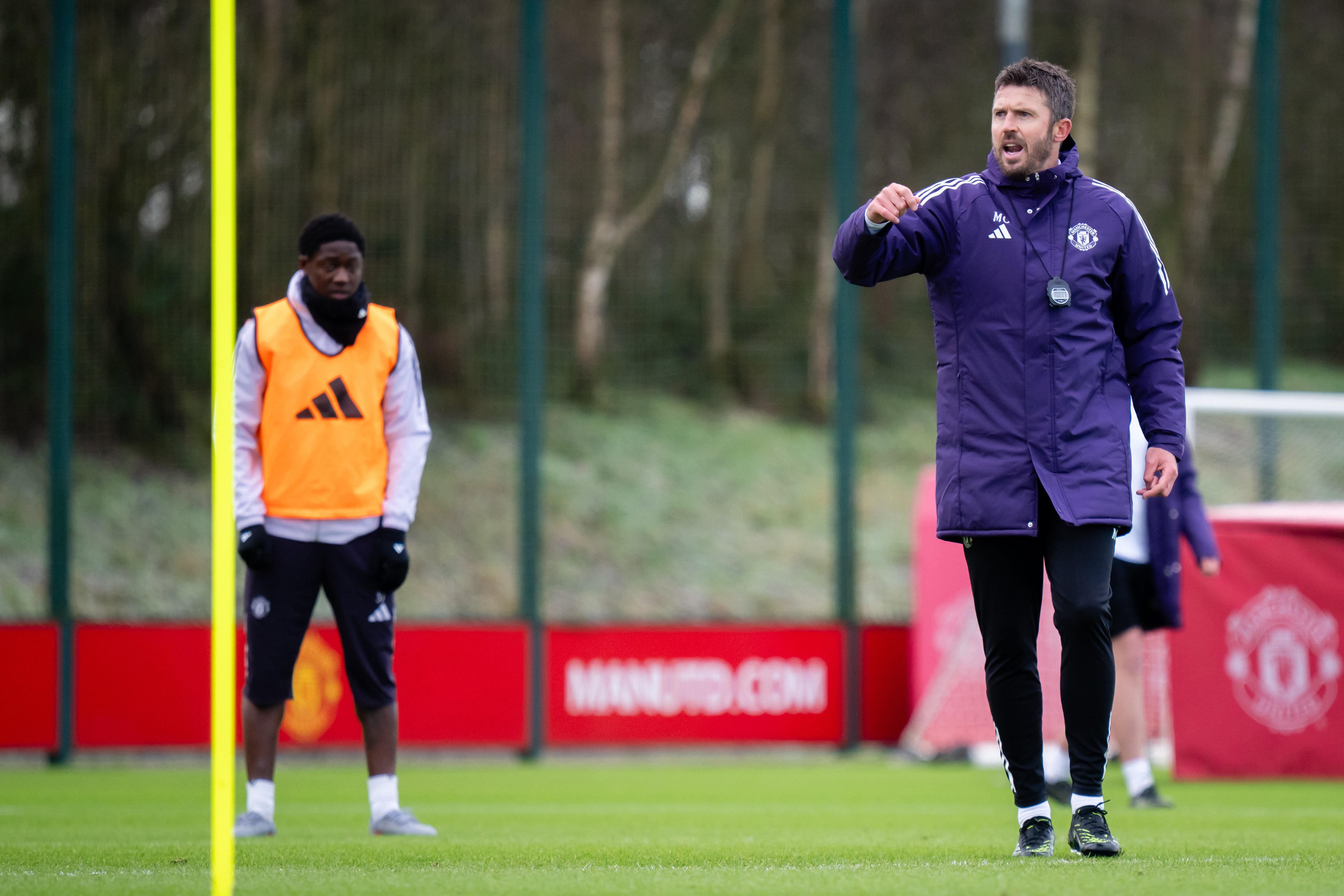 Michael Carrick gives instructions in Man United training as Mainoo watches on