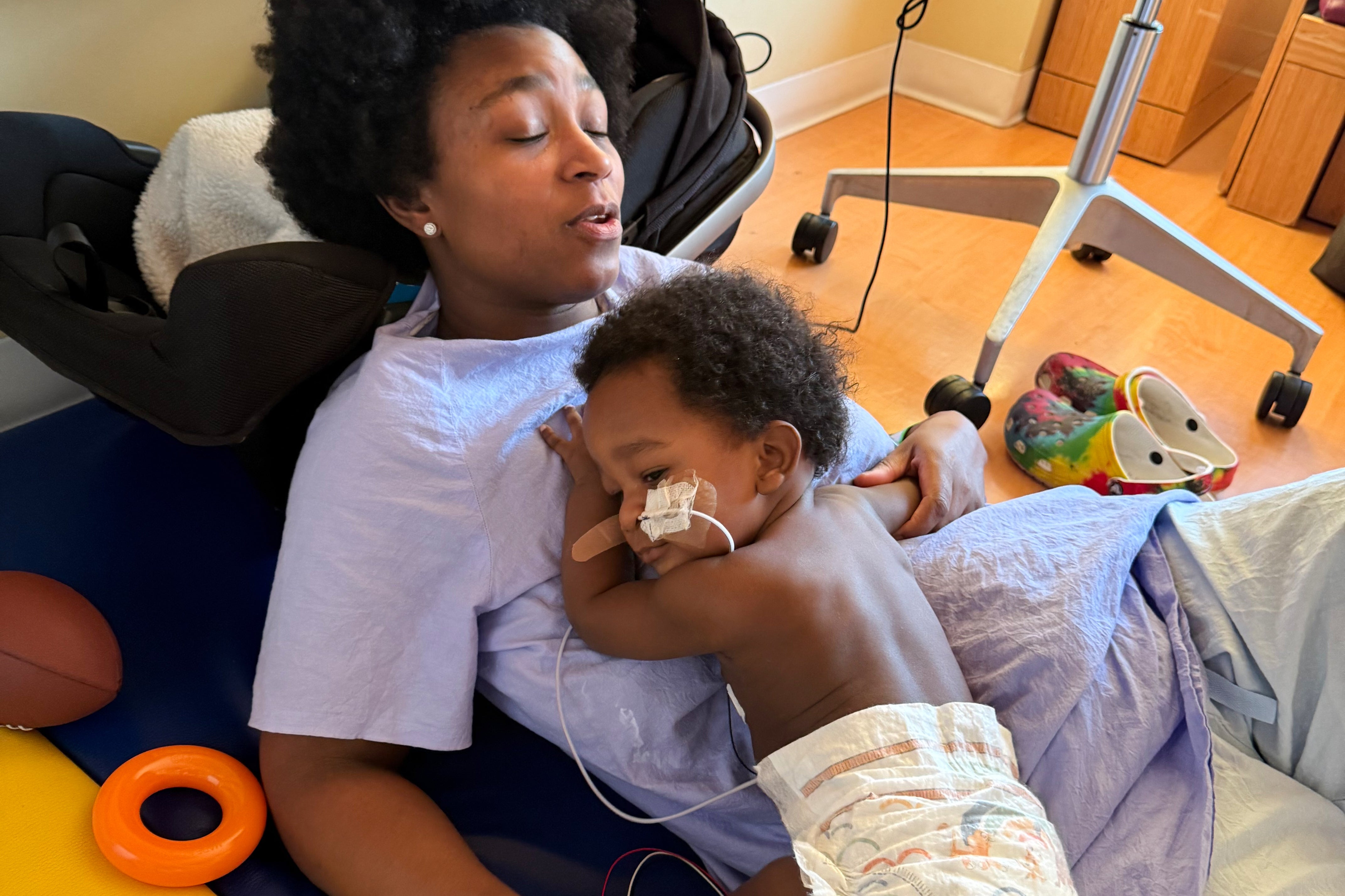 <p>Ashaan Carter lies on his mother, Angel Carter, at a children's hospital in Portland, Ore., in November 2025, during his treatment for infant botulism after drinking ByHeart baby formula donated to vulnerable families, before a national recall of all of the products. (David Orphey via AP)</p>