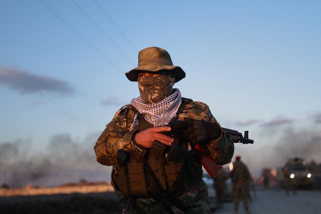 <p>A Syrian government fighter stands guard outside Al-Aqtan prison on the outskirts of Raqqa, northeastern Syria.</p>