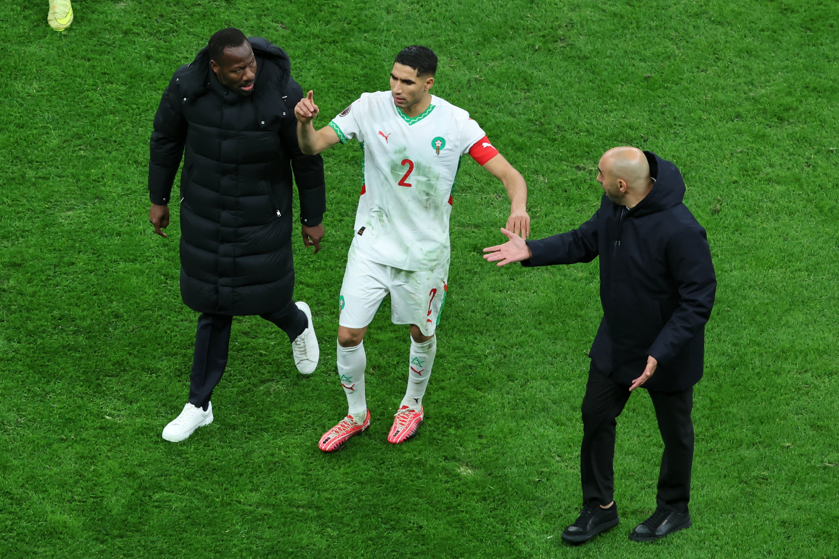 <p>Senegal’s head coach Pape Thiaw, left, speaks to Walid Regragui as he leaves the pitch </p>