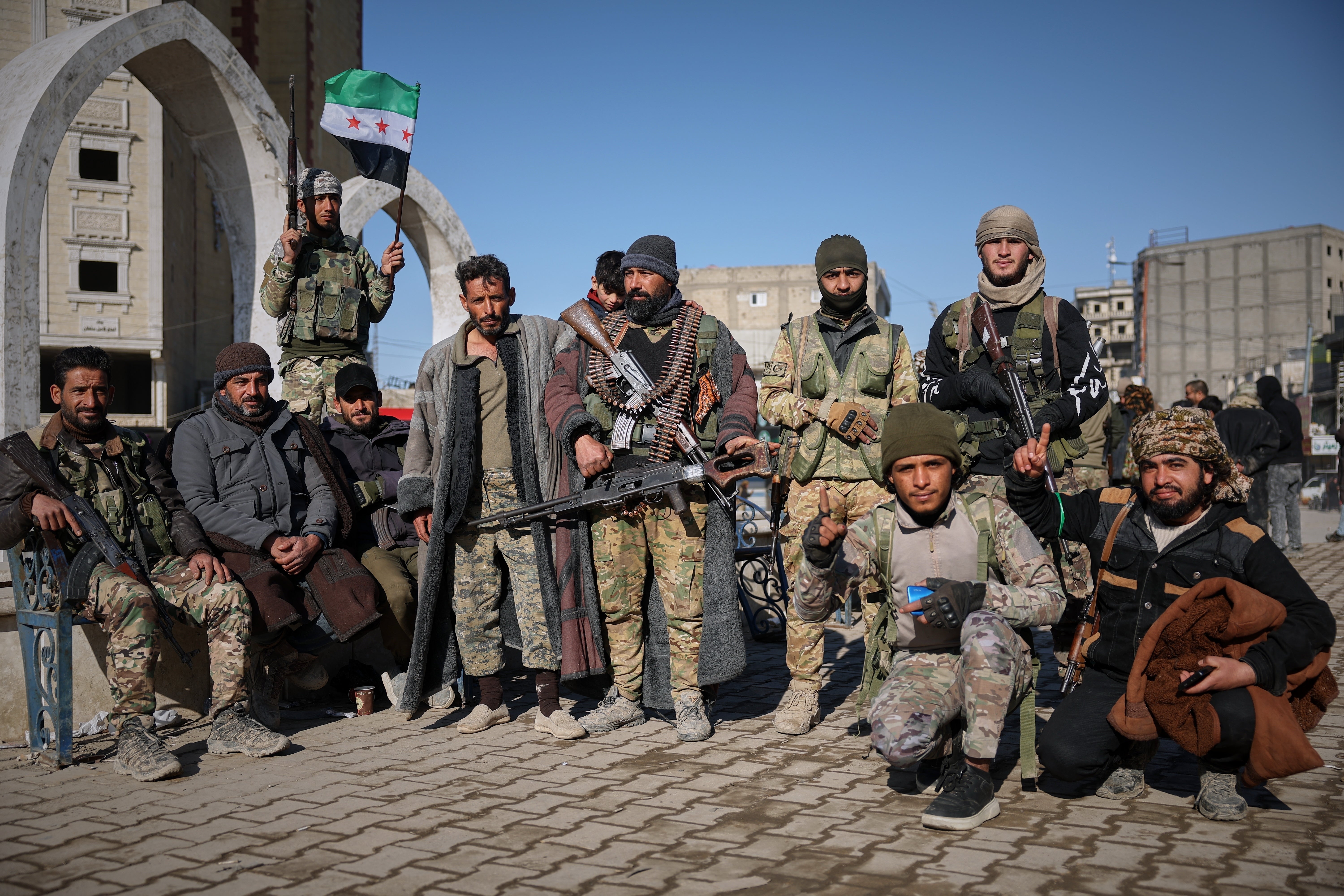 Tribal fighters pose for photographs taken by onlookers after Syrian government troops.