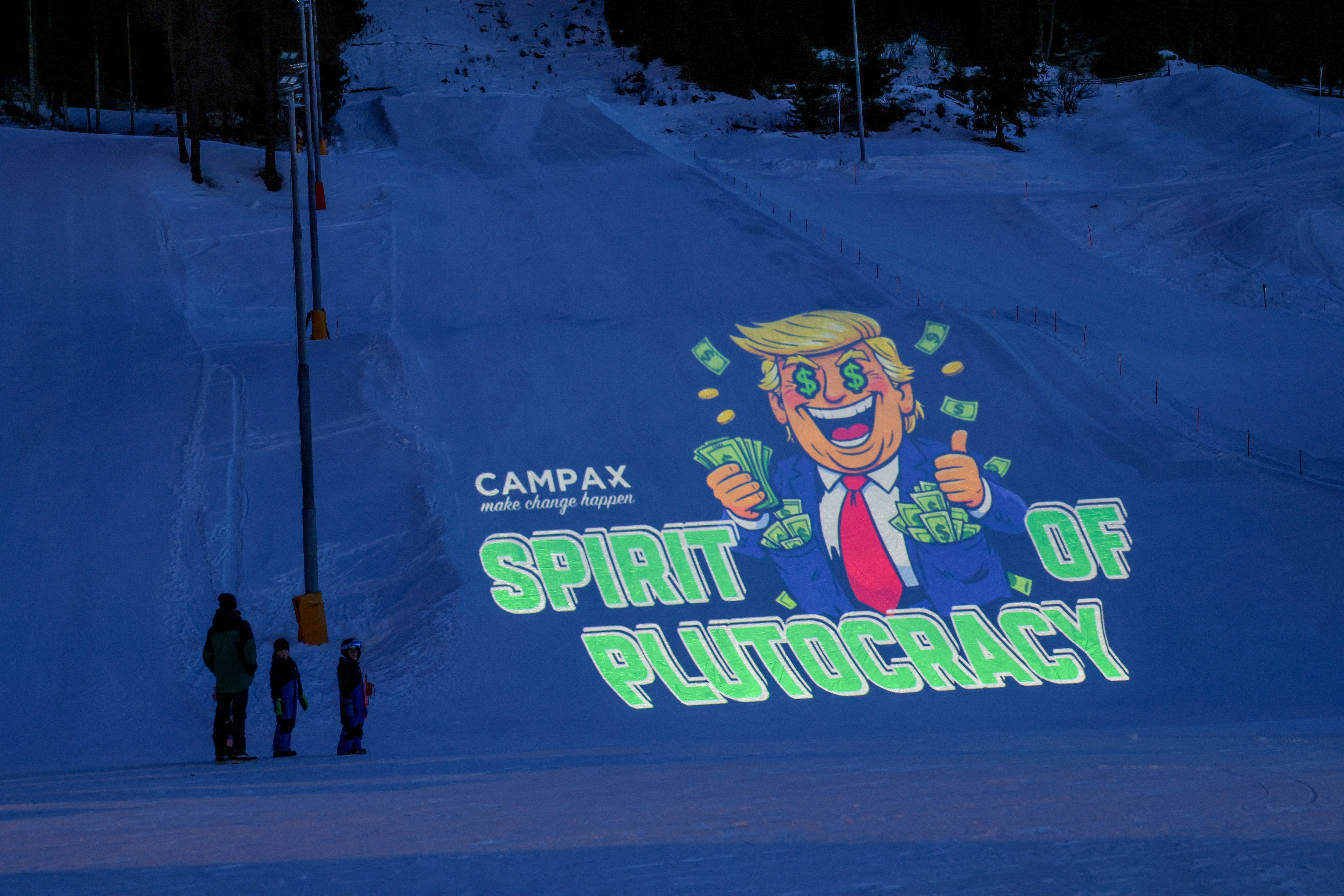 Activists from the Swiss NGO Campax projected a cartoon image of Trump onto a ski slope during a protest against his attendance