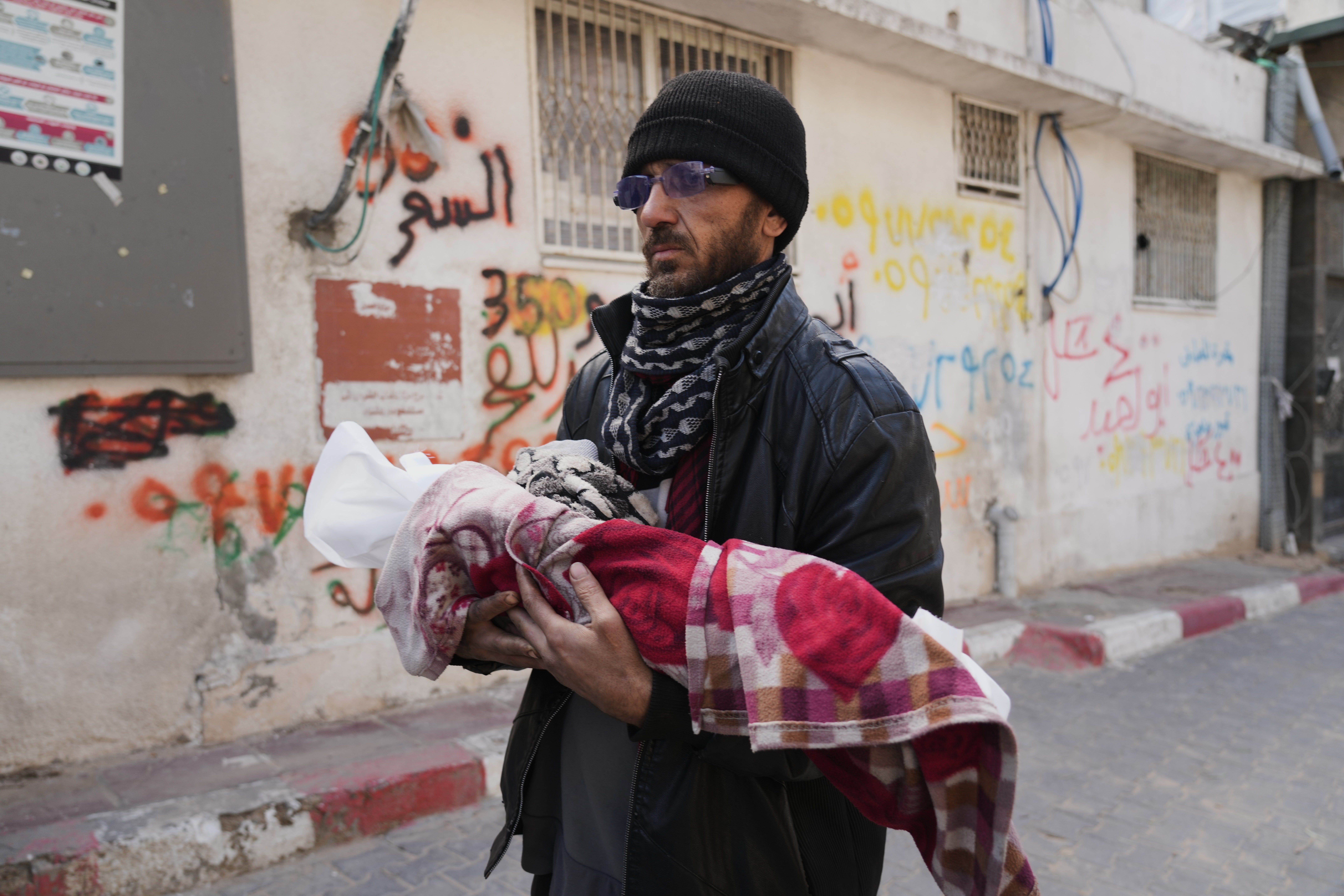 Khalid Abu Jarad holds the body of his three-month-old niece, Shaza Abu Jarad, who, according to the health ministry, died from hypothermia, in Gaza City, Tuesday, Jan. 20, 2026. (AP Photo/Jehad Alshrafi)