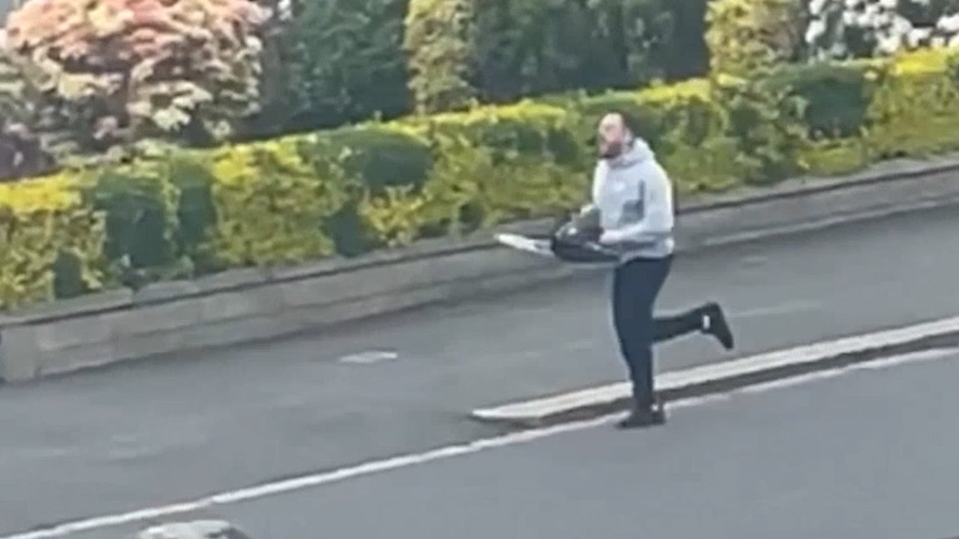 <p>Footage shows chainsaw thug chasing police officer down street </p>
