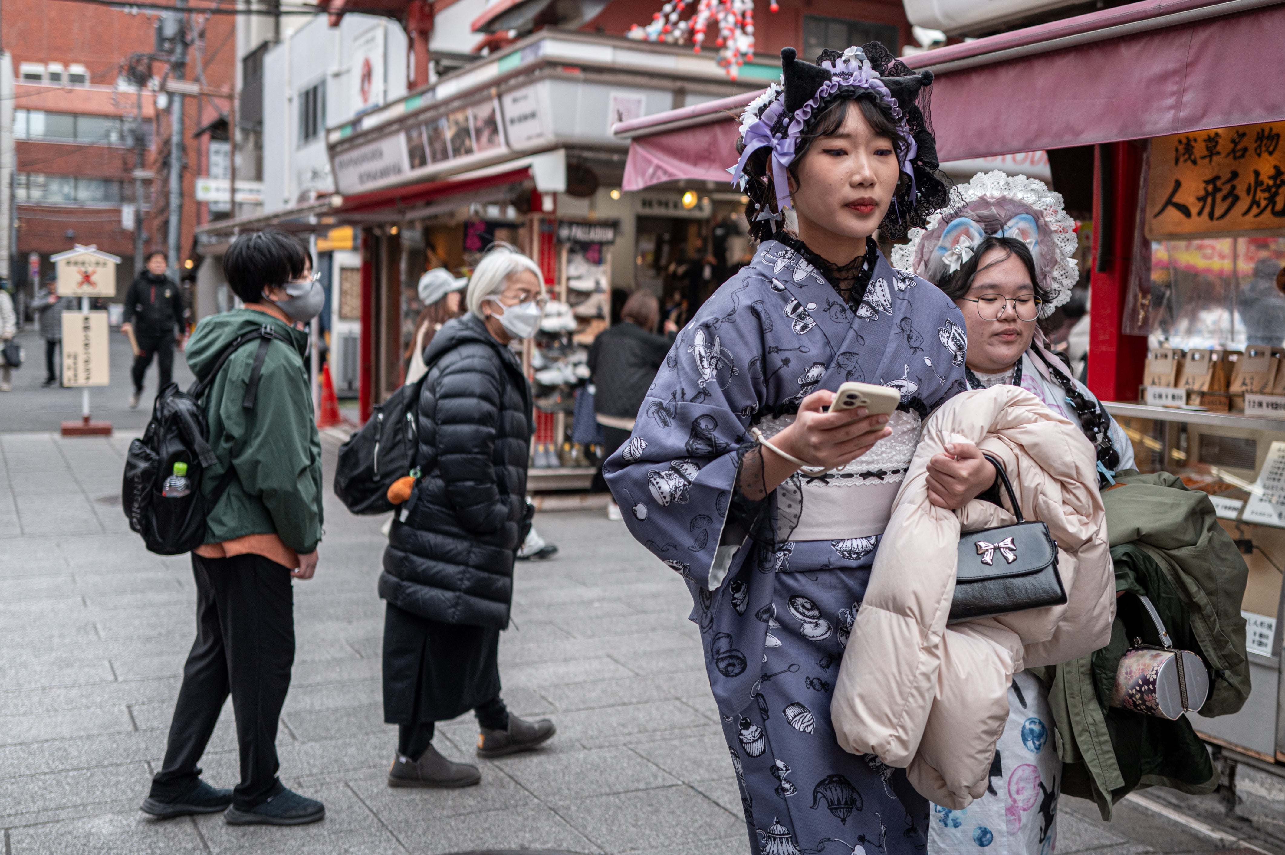 People visit a shopping street in the Asakusa district near Sensoji Temple, a popular tourist location in Tokyo, on 20 January 2026