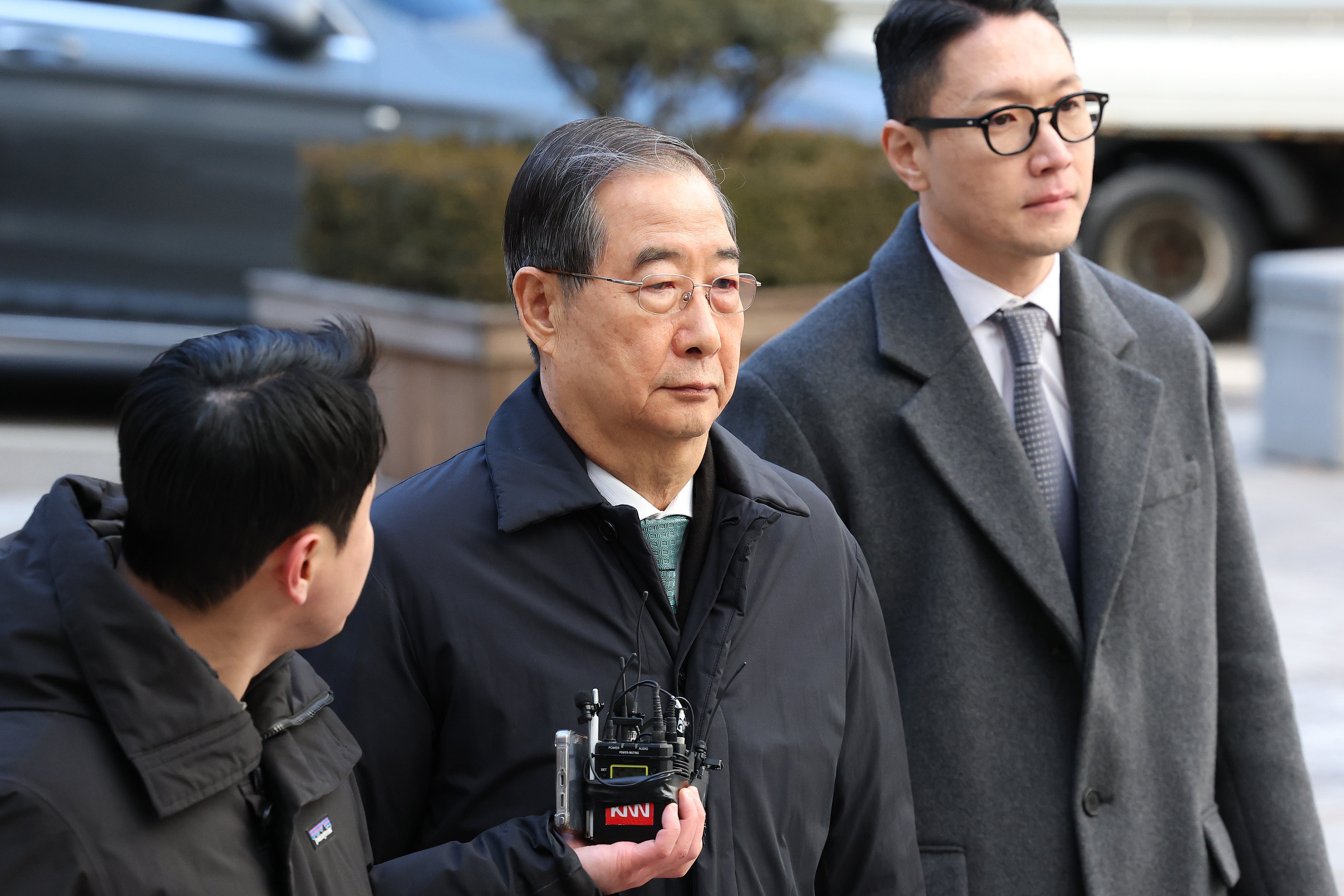 Former South Korean Prime Minister Han Duck-soo, center, arrives at the Seoul Central District Court for his first sentencing trial in the insurrection case, in Seoul Wednesday, Jan. 21, 2026. (Chung Sung-Jun/Pool Photo via AP)