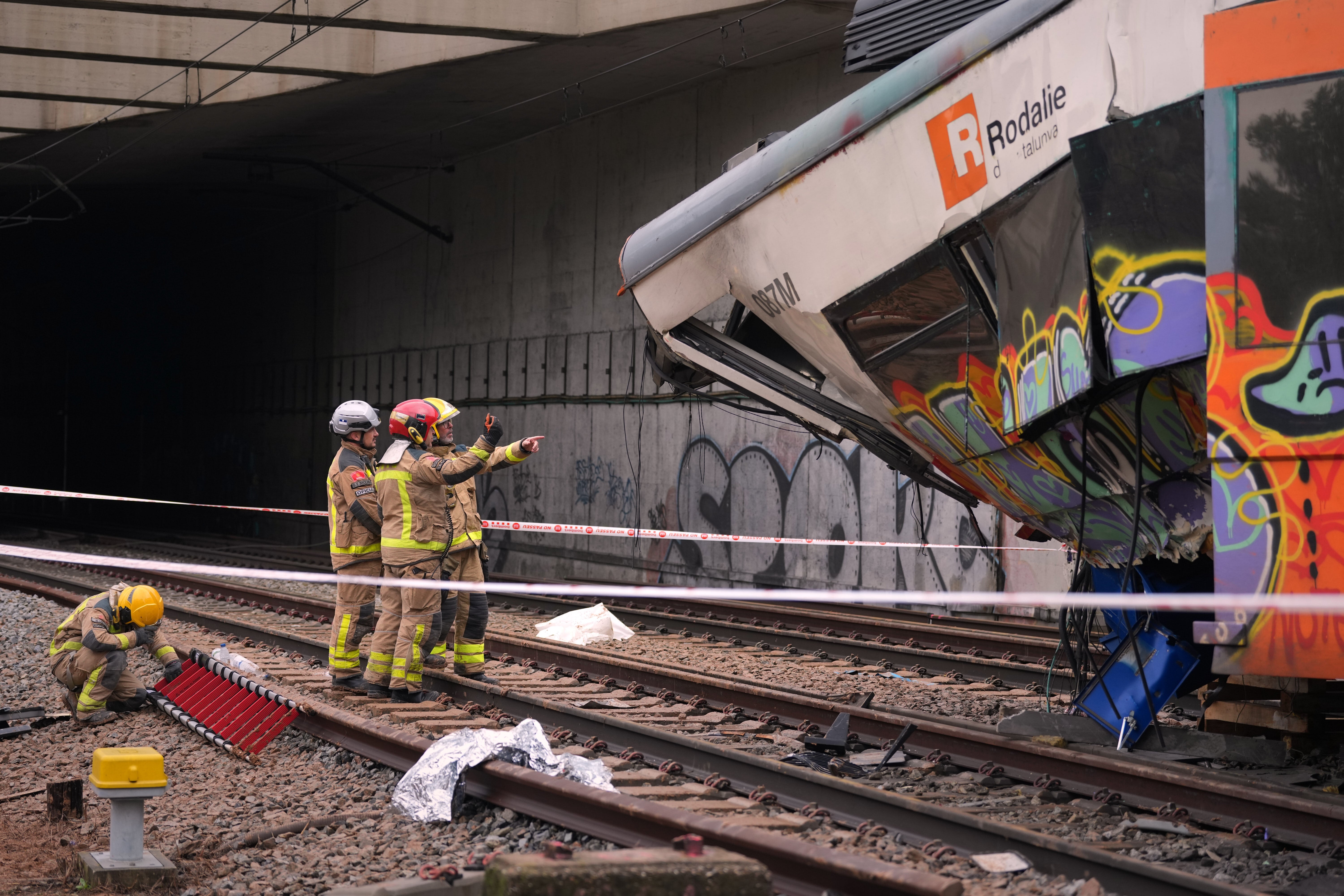Firefighters inspect the damage after a commuter train derailed as a retaining wall collapsed onto the tracks in Gelida, near Barcelona, Spain on 21 January, 2026