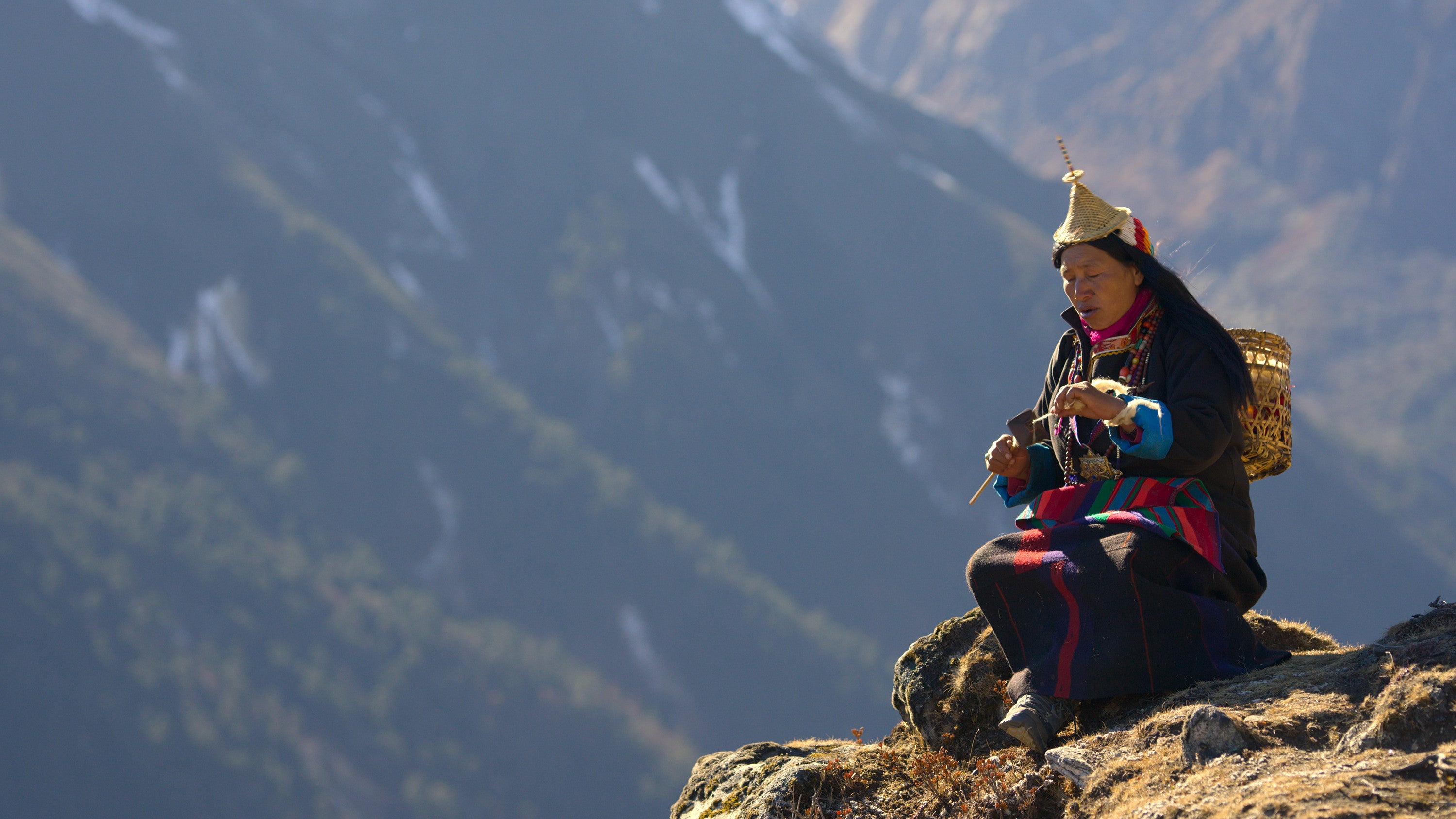 Aum Passang, one of the Layap people, sits on the side of a mountain singing