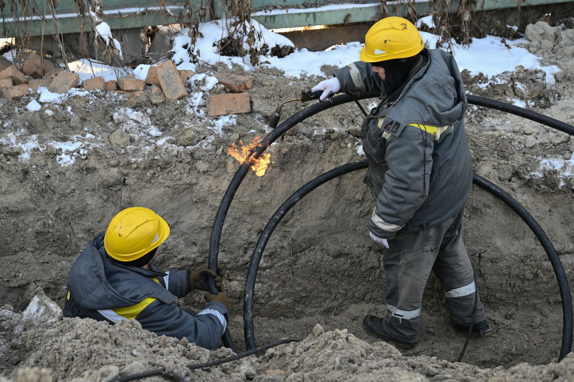Workers from Ukraine's largest energy provider DTEK carry out emergency repairs of a power line in freezing conditions following Russian missile and drone attacks on Ukrainian energy infrastructure in Kyiv on January 20, 2026, amid the Russian invasion in Ukraine. (Photo by Genya SAVILOV / AFP via Getty Images)