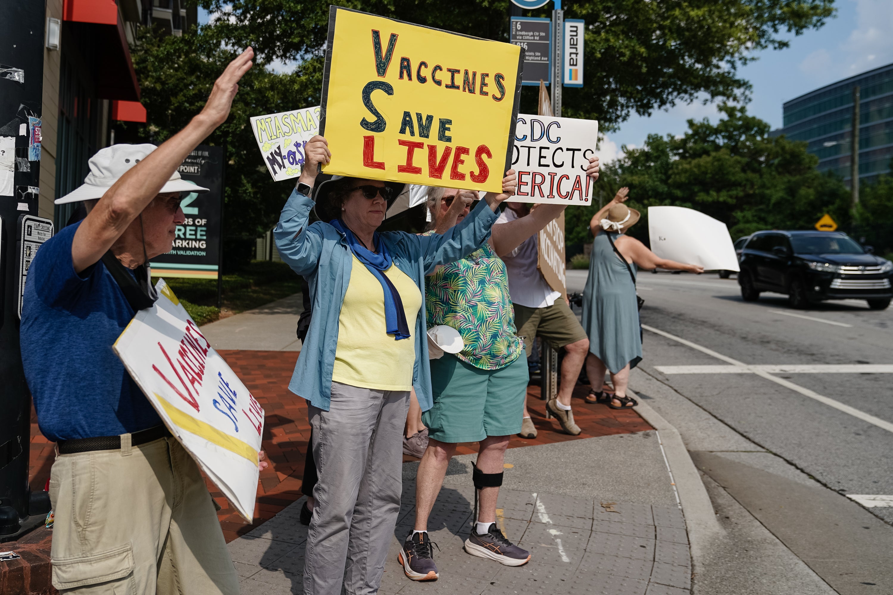 Protesters hold signs about the life-saving power of vaccines outside the CDC headquarters in Georgia last June. One of the agency’s top officials is under fire after he reportedly claimed that America possibly losing its longstanding measles elimination status is the ‘cost of doing business’ in a global economy