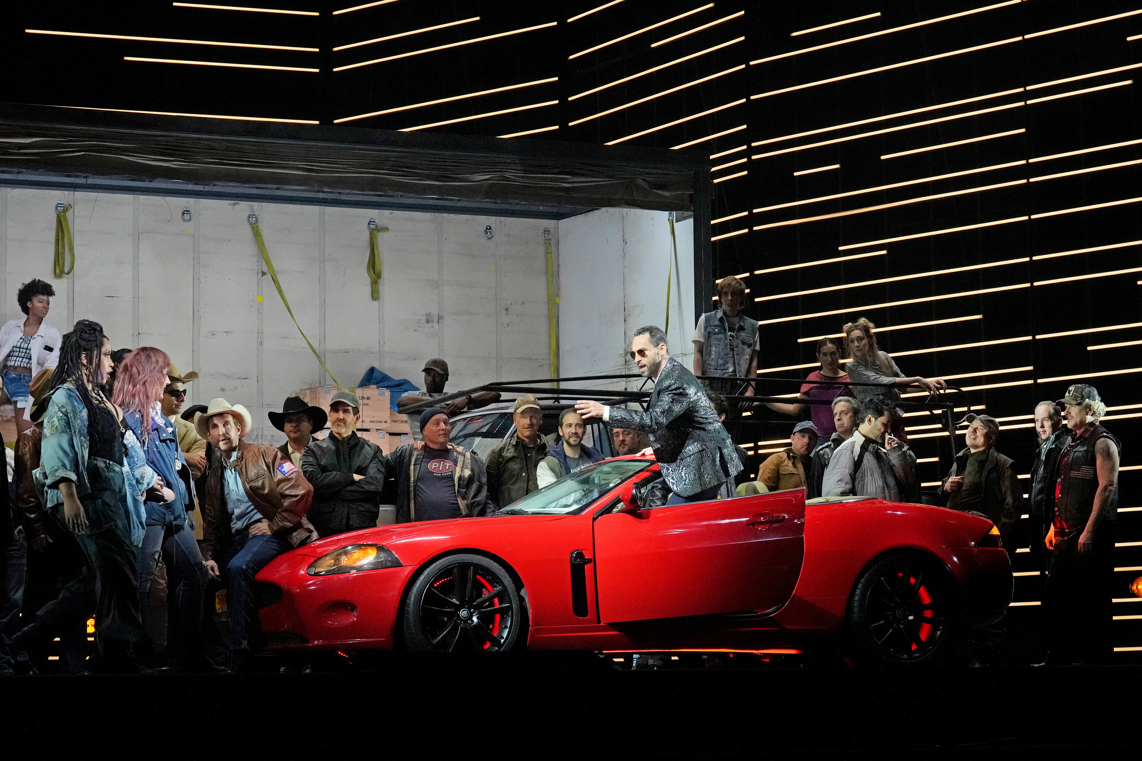 This image released by the Metropolitan Opera shows bass-baritone Kyle Ketelsen, in the red car, during a rehearsal of Bizet’s ‘Carmen’ at the Metropolitan Opera in New York on Dec. 28, 2023. (Ken Howard/Met Opera via AP)