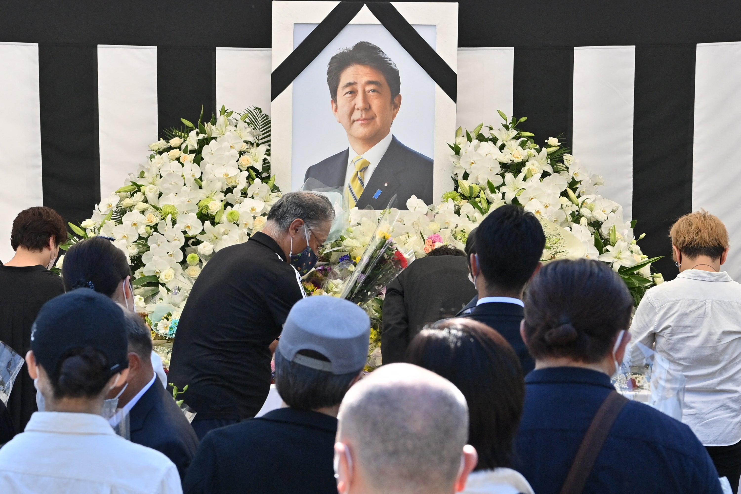 This photo taken on 27 September 2022 shows people offering their respects to former Japanese prime minister Shinzo Abe outside the Nippon Budokan in Tokyo, ahead of his state funeral later in the day