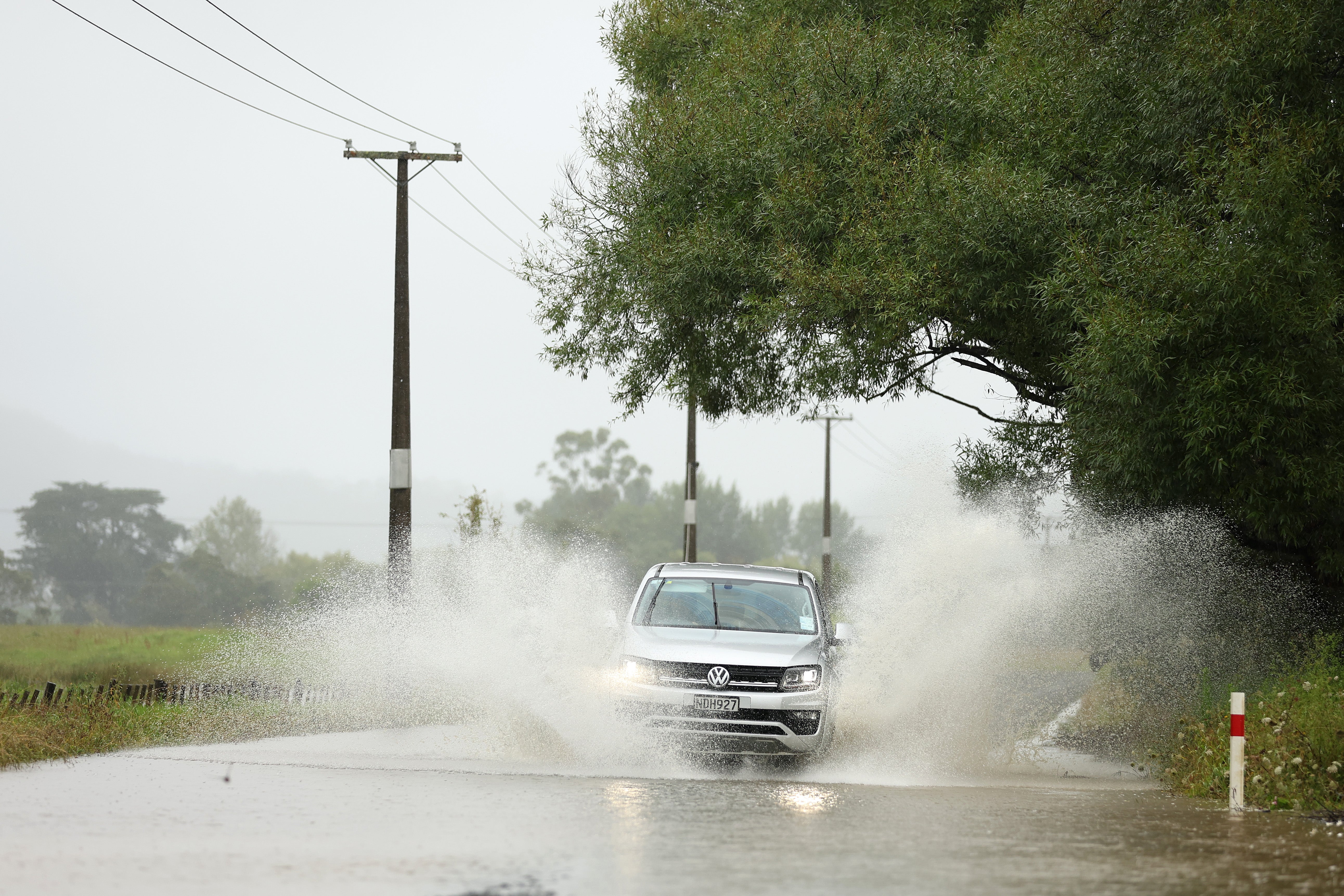 A car drives through flooding in Kaipara Flats on January 21, 2026 in Auckland, New Zealand