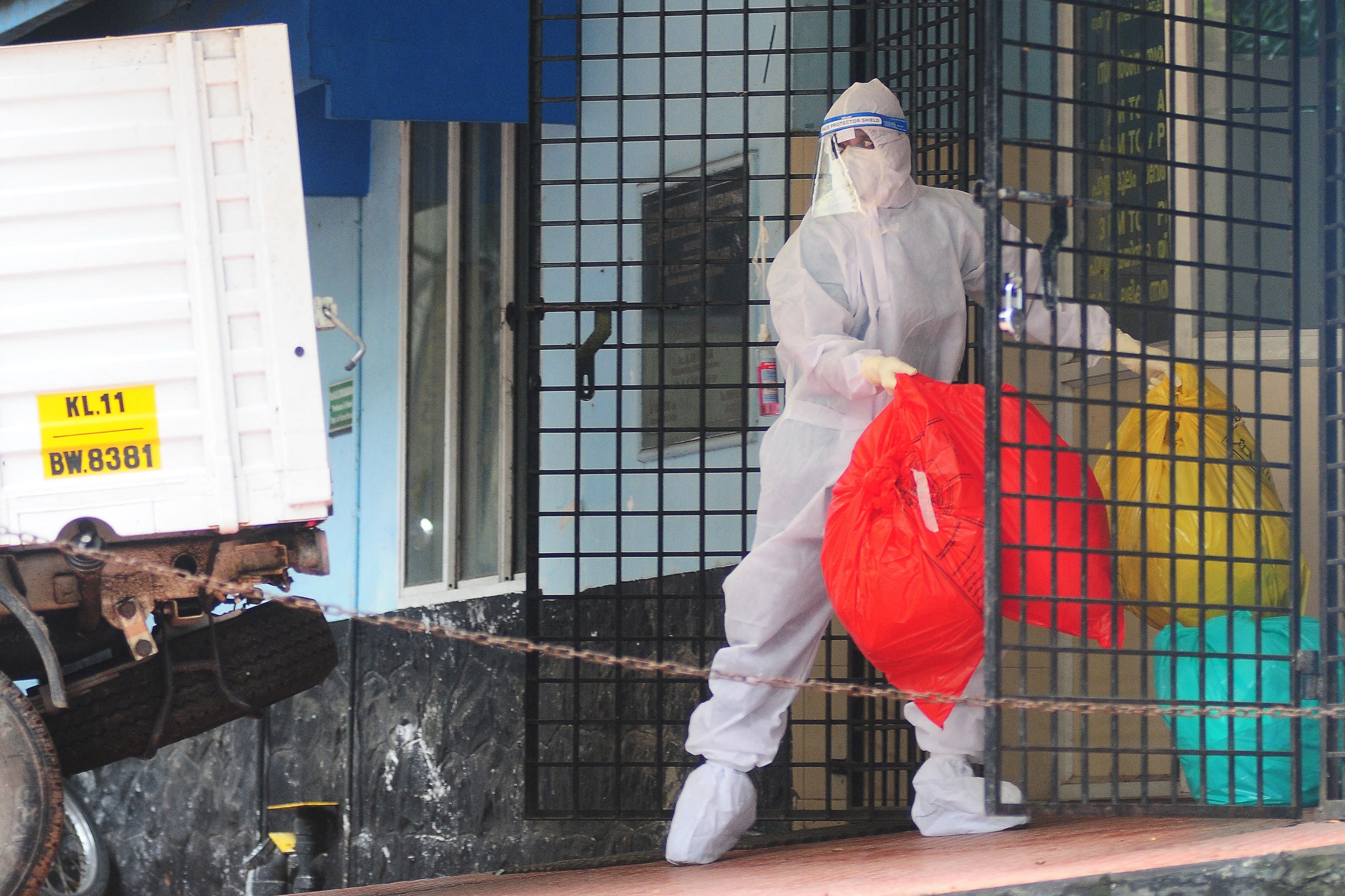 A health worker wearing protective gear disposes biohazard waste from a Nipah virus isolation center at a goverment hospital in Kozikode, in India's southern state of Kerala