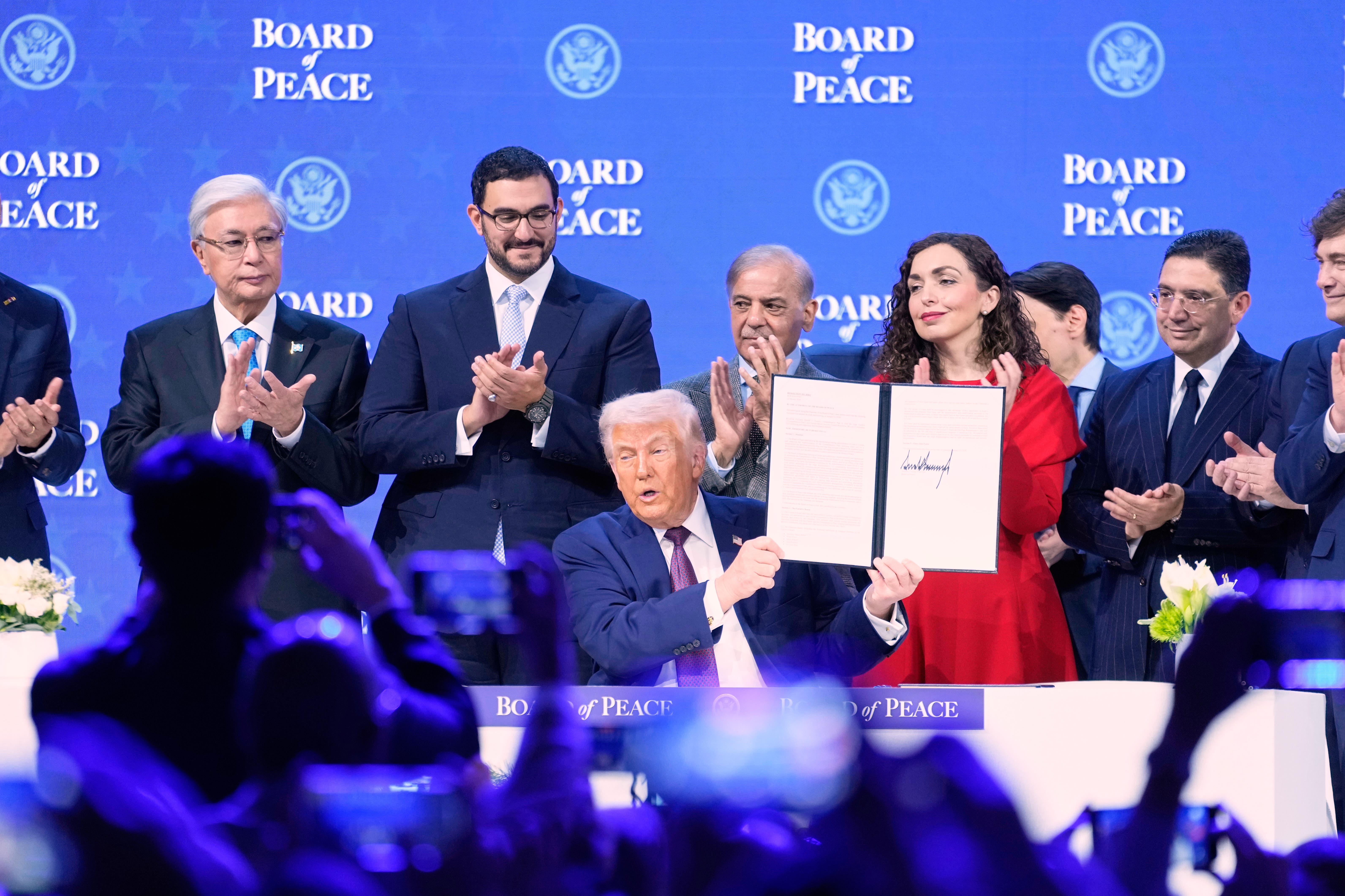 Donald Trump holding the charter during a signing ceremony on his Board of Peace initiative at the World Economic Forum (AP/Markus Schreiber)