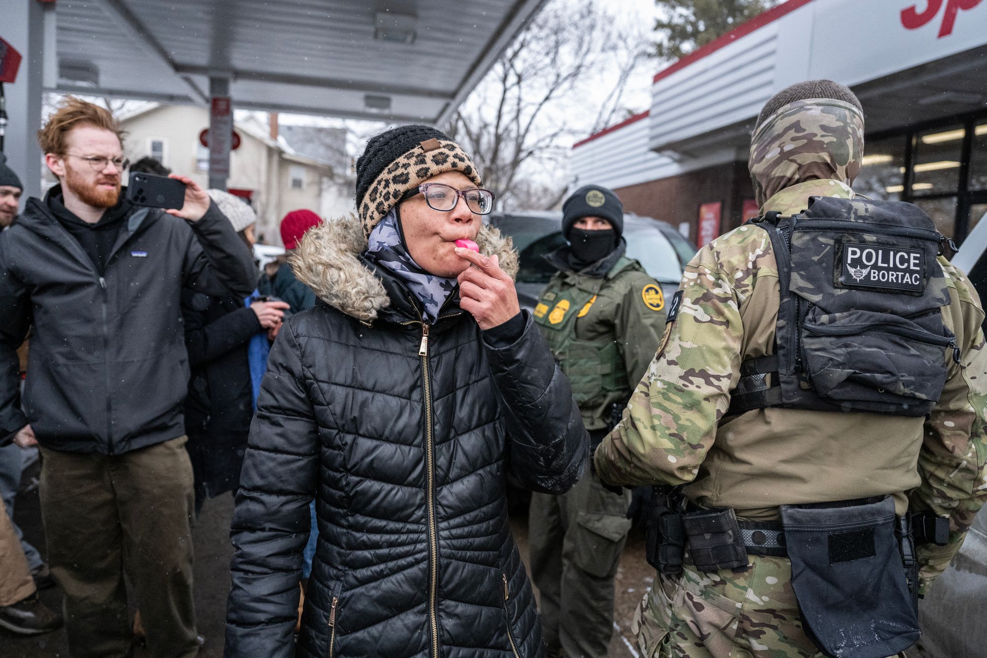 A protester blows a whistle at U.S. Border Patrol agents in Minneapolis Wednesday