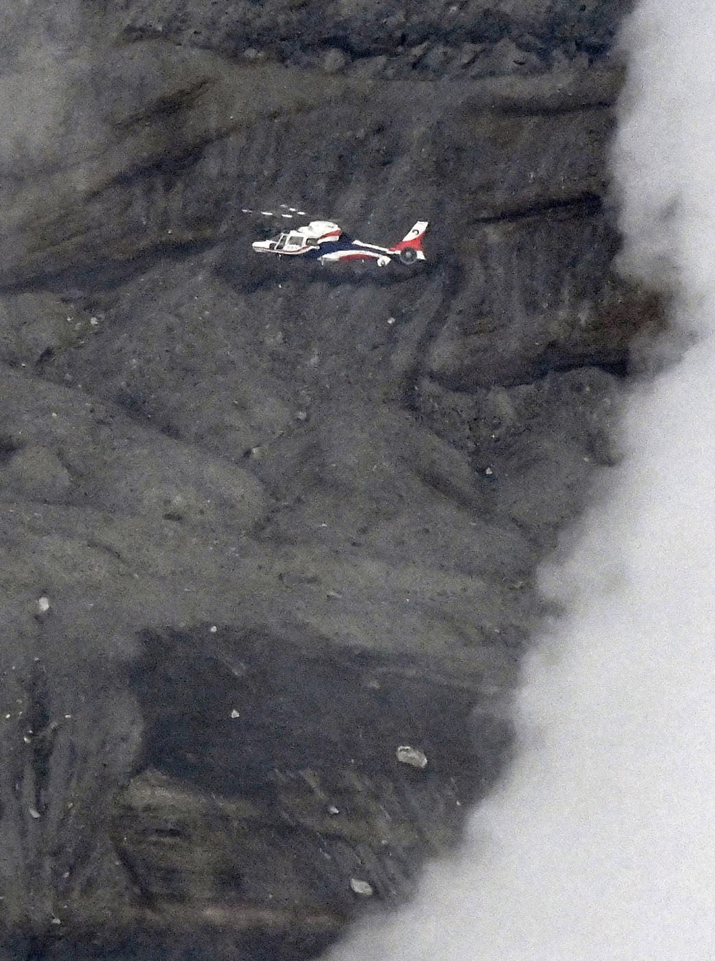 A prefectural disaster prevention helicopter searches near the Nakadake crater of Mount Aso in Kumamoto prefecture, southwestern Japan, Tuesday, 20 January 2026, where a sightseeing helicopter went missing