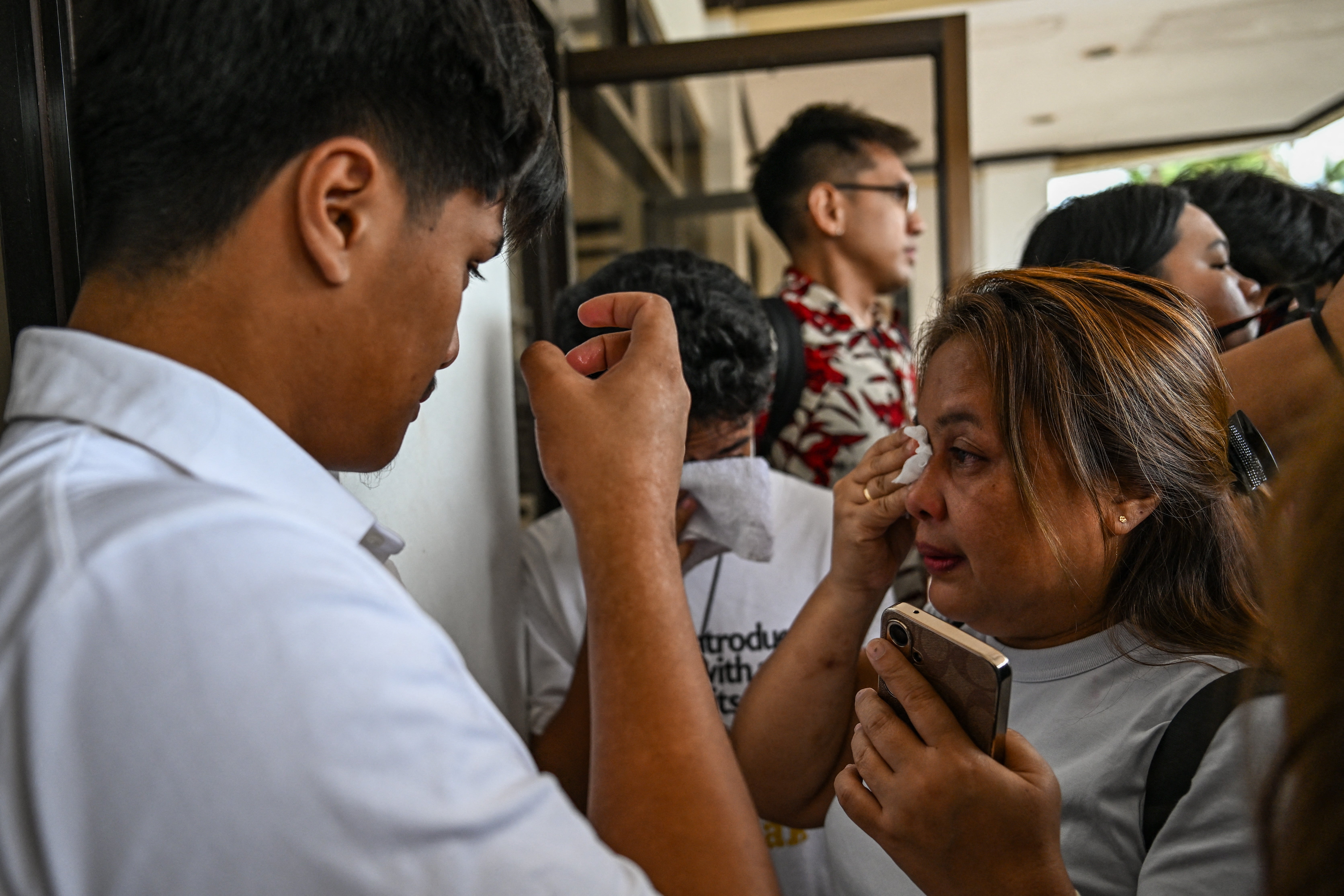 Lala Cumpio (R), mother of the detained Filipino journalist Frenchie Mae Cumpio, cries outside the Tacloban Regional Trial Court in Leyte island on 22 January 2026, after the promulgation of her daughter’s court case