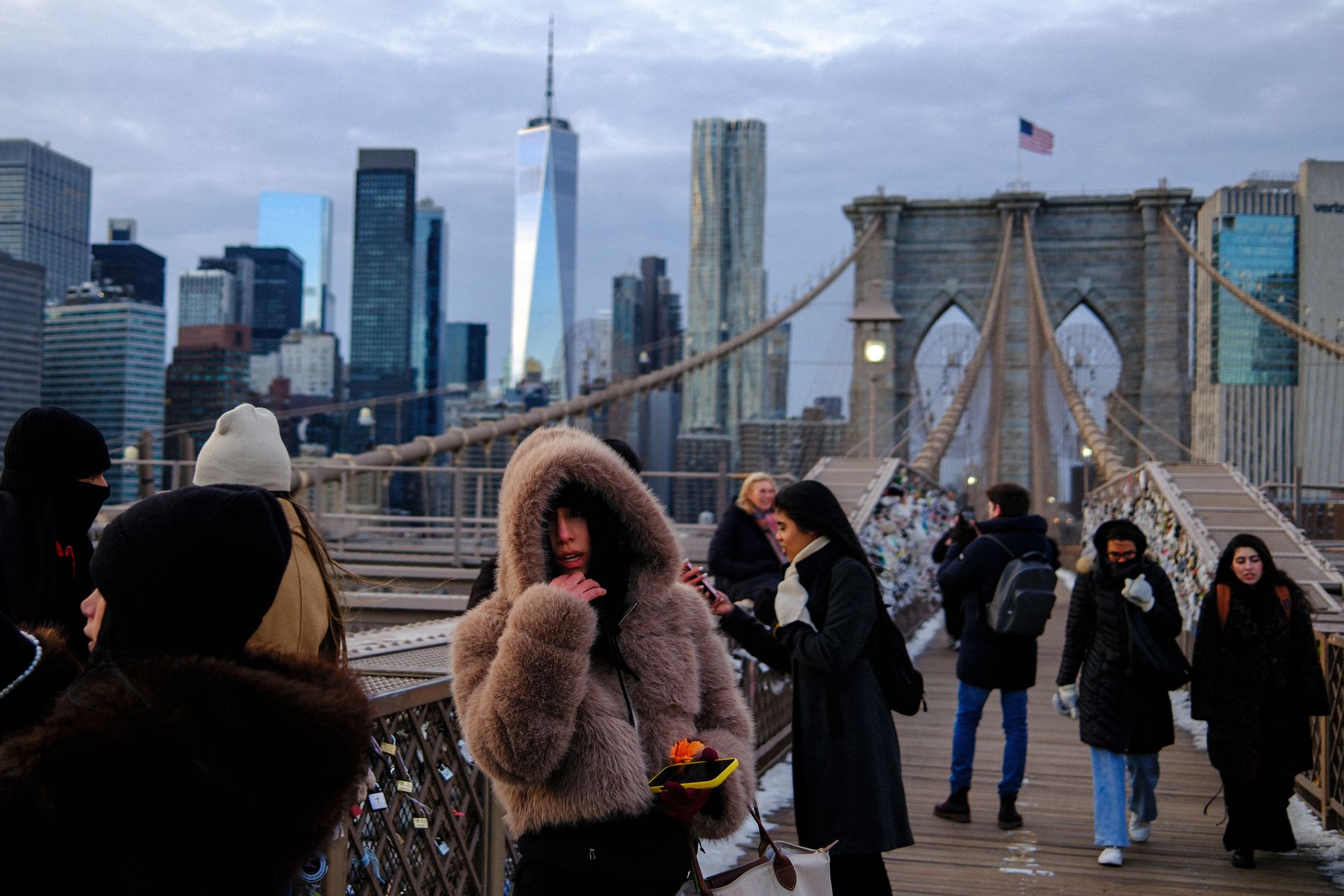 People brave cold temperatures while walking on the Brooklyn Bridge ahead of a winter storm expected to bring heavy snow and ice to the region