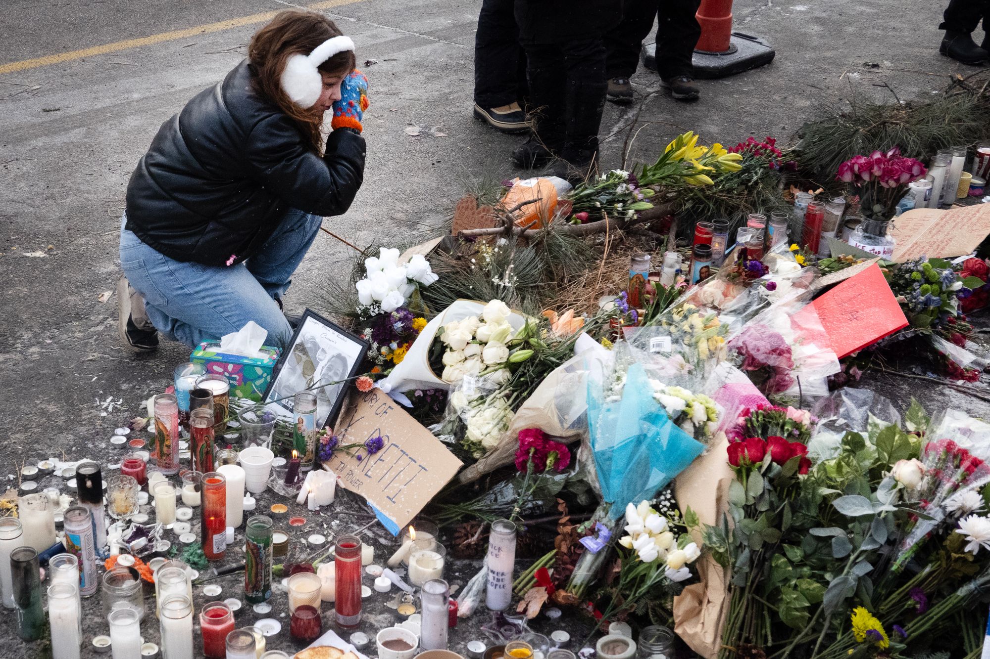 A woman wipes away a tear while visiting a memorial to Alex Pretti on January 25, 2026 in Minneapolis