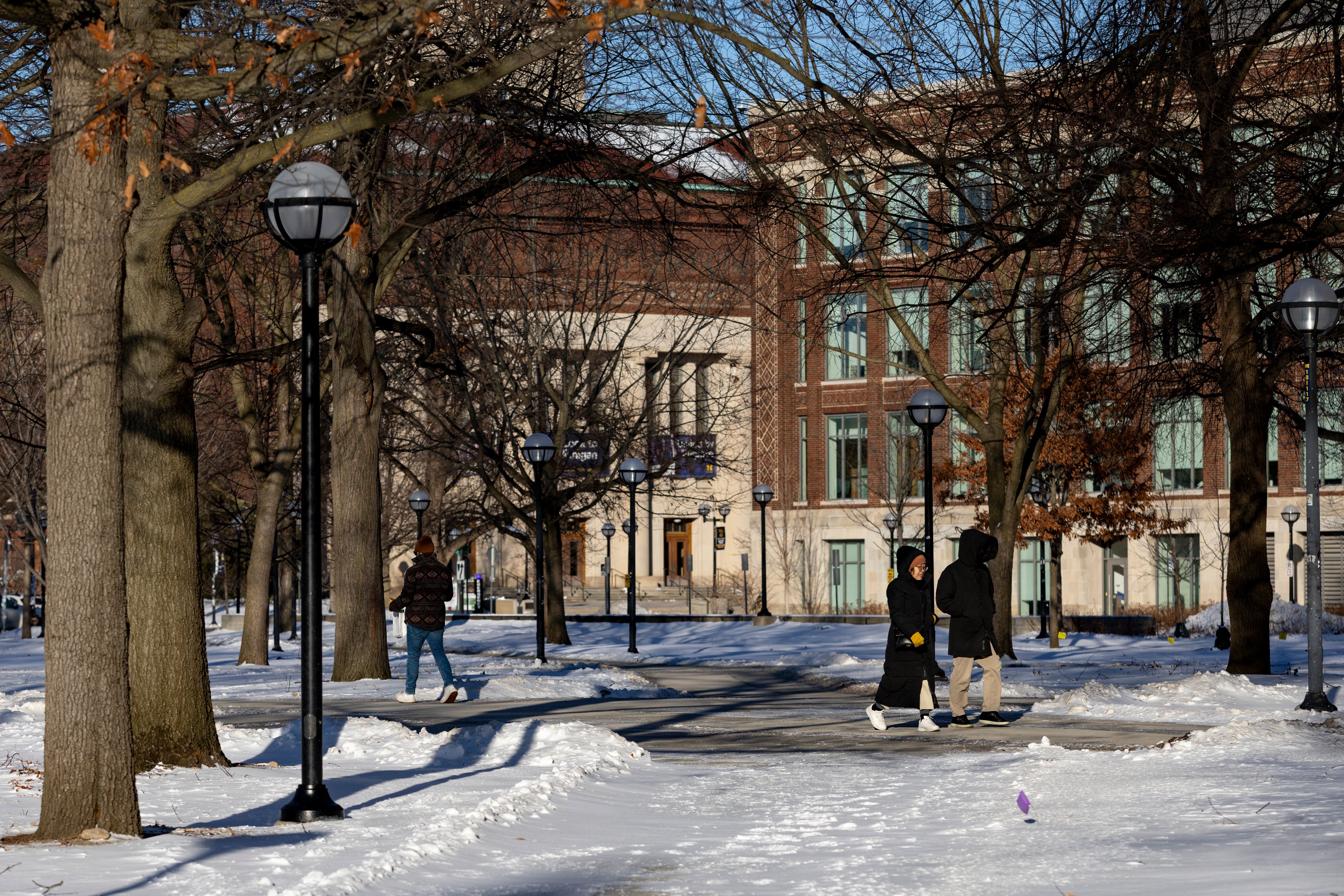 People walk around the University of Michigan campus in Ann Arbor, Mich., Jan. 17, 2026. (AP Photo/Emily Elconin)