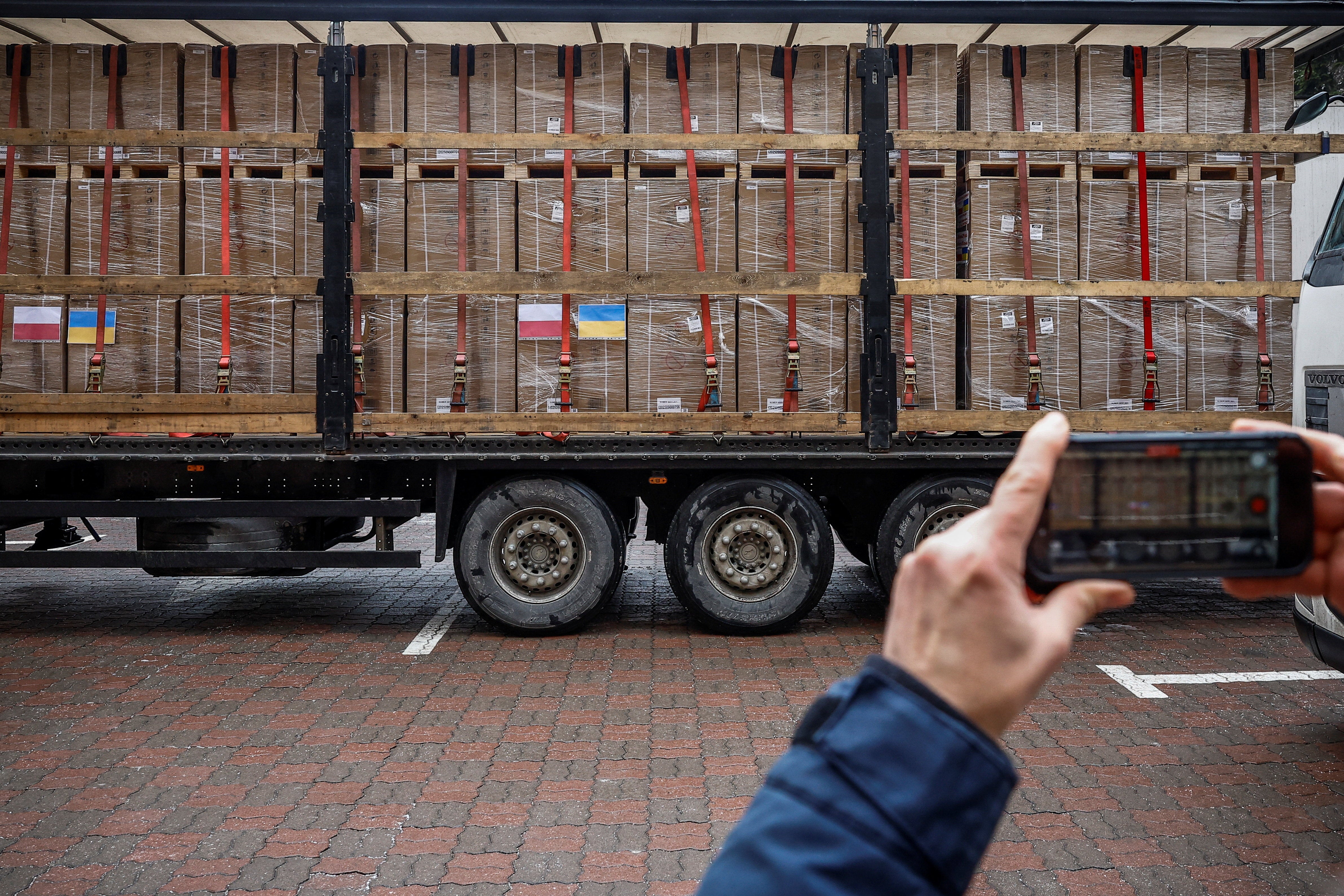 Person takes a picture of generators, which Kyiv received from Poland as the country faces power outages after recent Russian missile and drone strikes on critical infrastructure, as a humanitarian aid