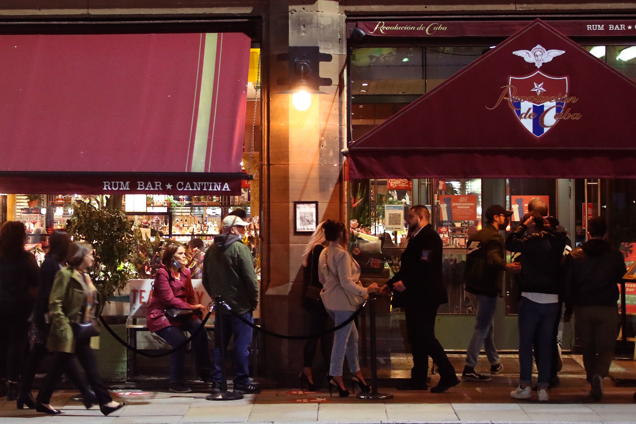 People outside the Revolucion de Cuba bar in Manchester, ahead of a possible government announcement on Monday. Cities in northern England and other areas suffering a surge in Covid-19 cases may have pubs and restaurants temporarily closed to combat the spread of the virus.
