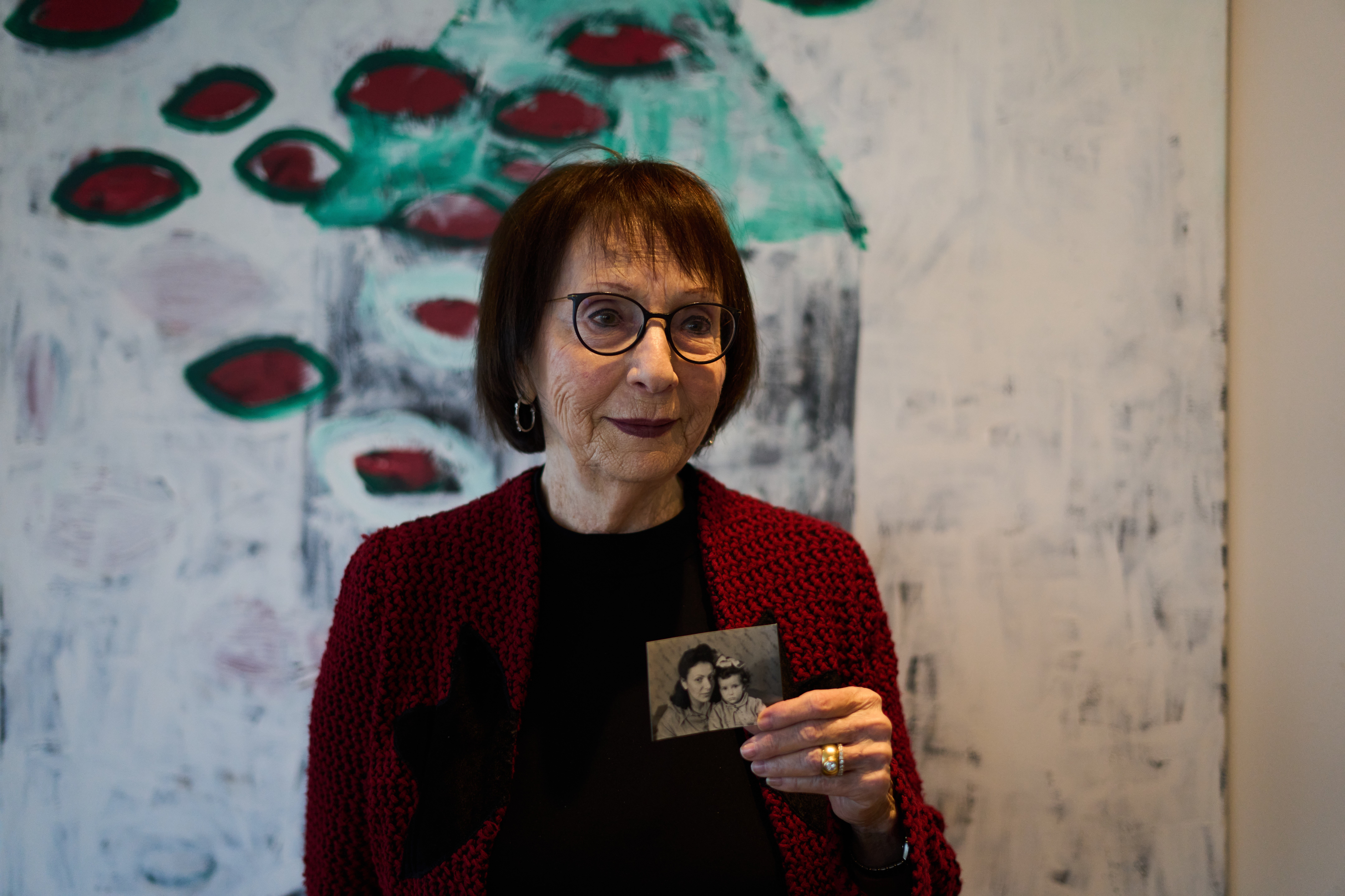Holocaust survivor Ilana Shalem-Kantorowics, born in the Nazi Bergen-Belsen concentration camp, holds a photo of her with her mother Lola taken in the camp in 1946.