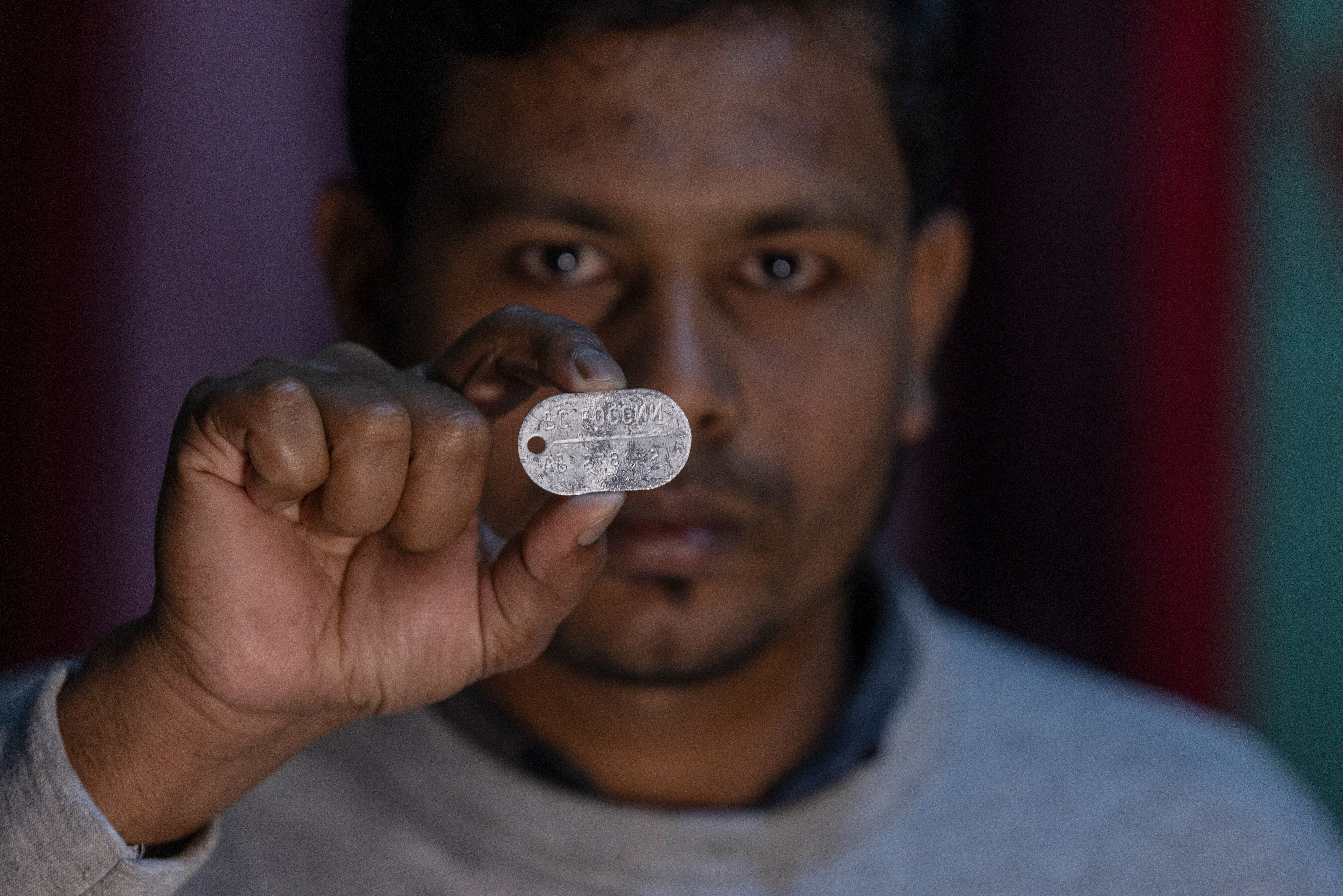 Maksudur Rahman, 31, who escaped after fighting for the Russian army, shows a Russian military dog tag during an interview with The Associated Press in Lakshmipur, Bangladesh, Dec. 10, 2025. (AP Photo/Rajib Dhar)