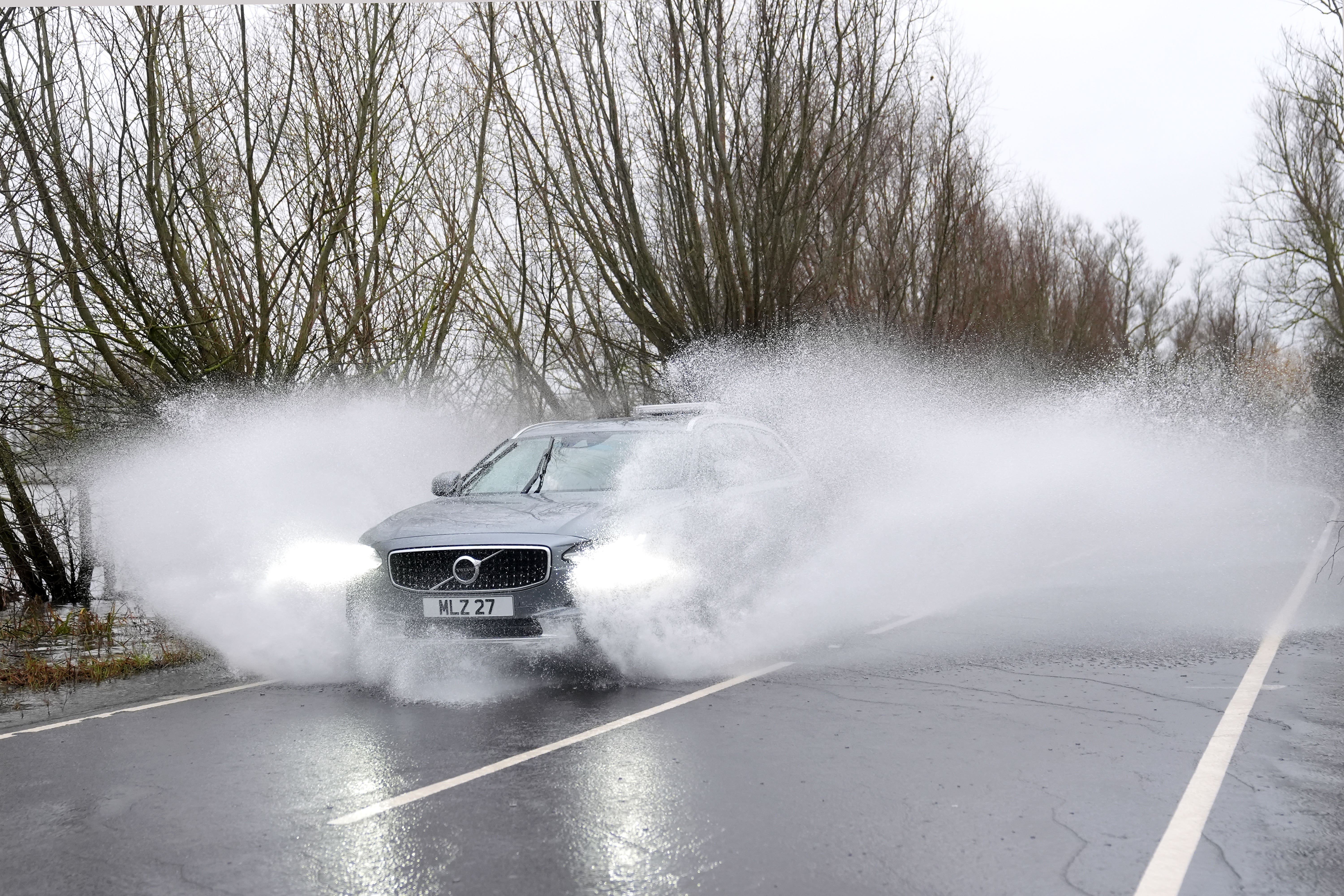 A vehicle passes through surface water on the flooded A1101 in Welney, Norfolk (Joe Giddens/PA)