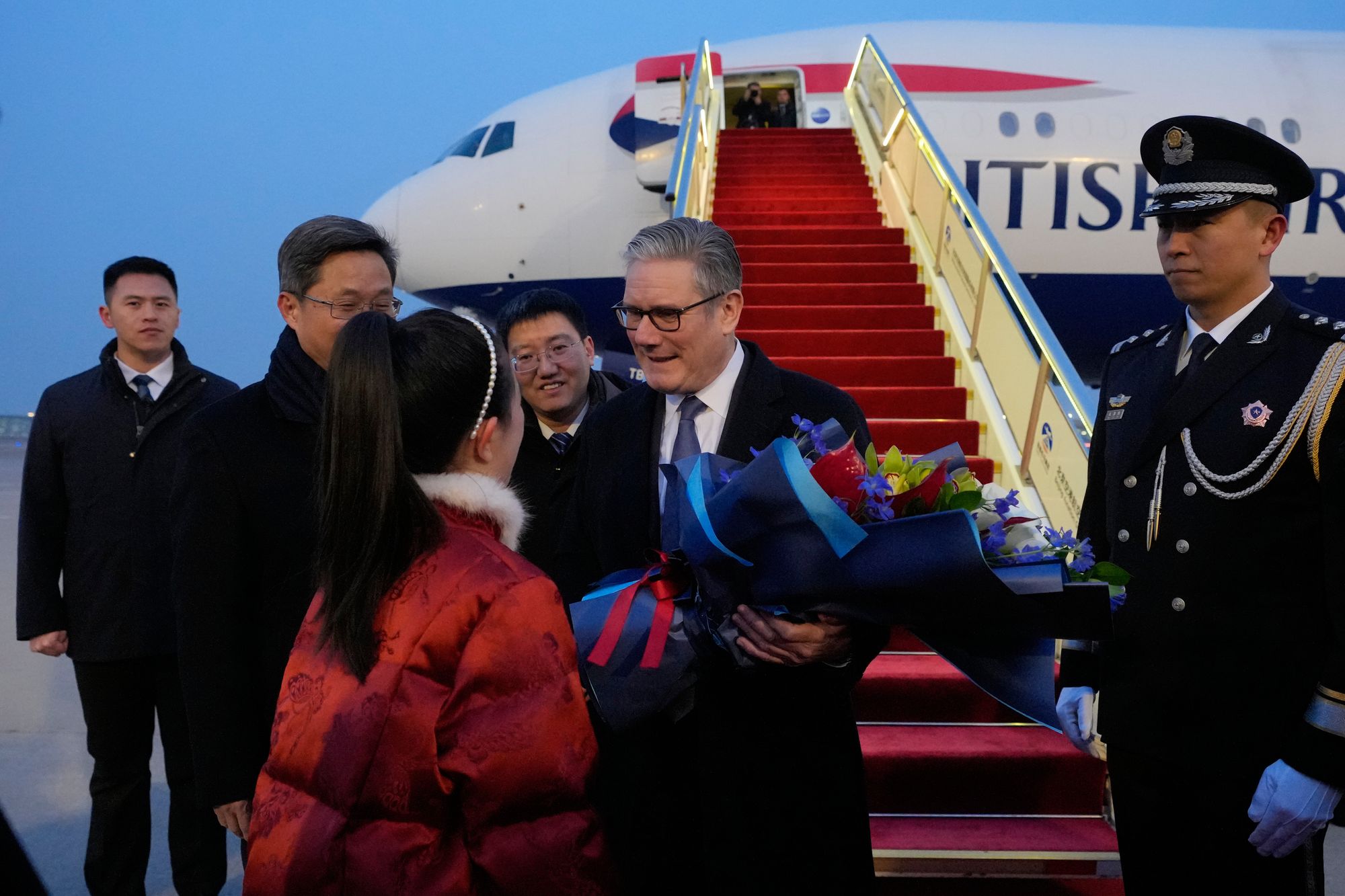 The PM being presented with flowers on his arrival to China