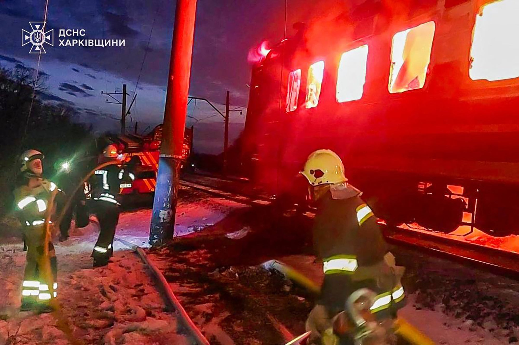 Ukrainian rescuers work to extinguish a fire in a train carriage following an air attack at an undisclosed location in the Kharkiv region