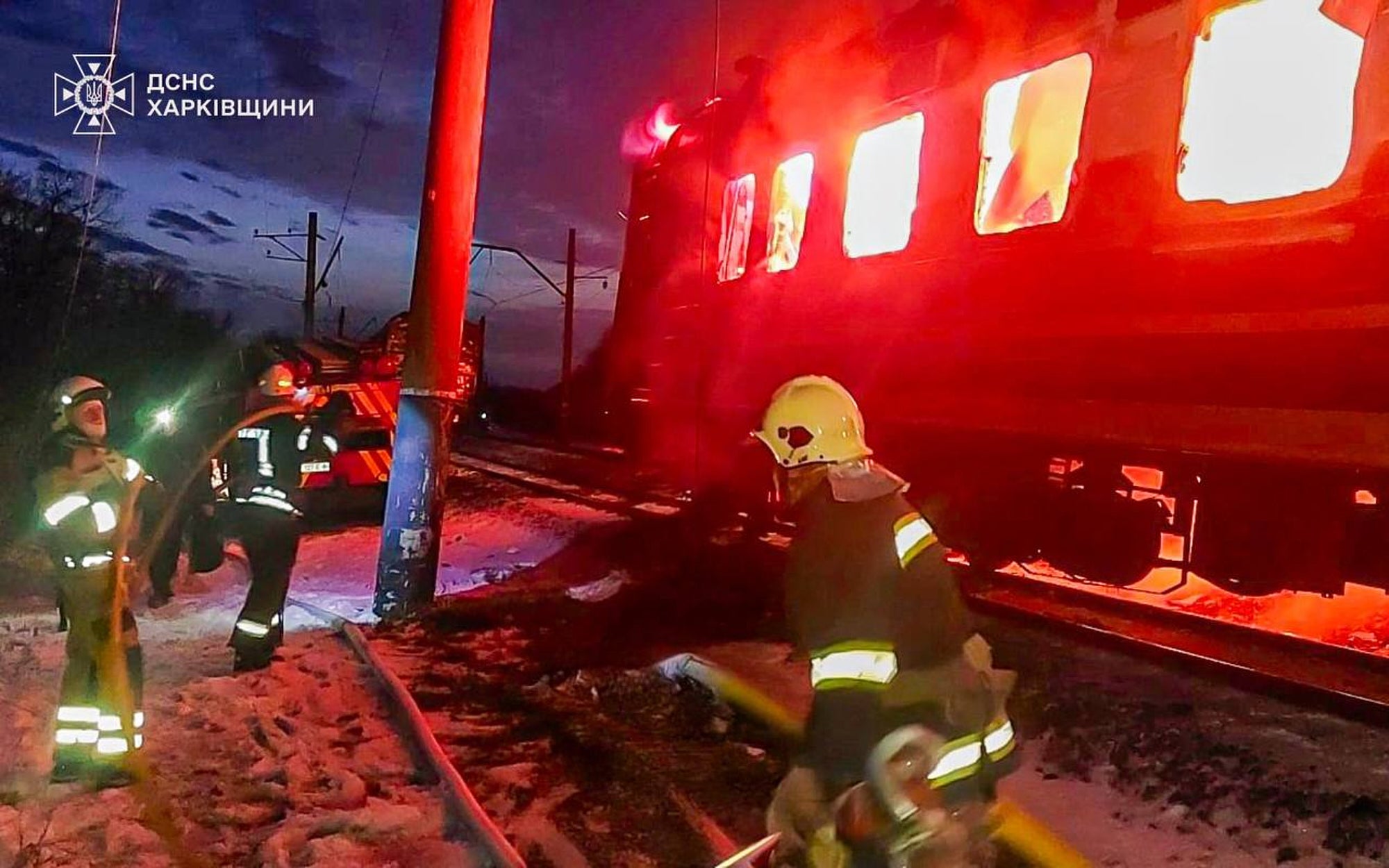 Firefighters put out the fire after Russian drones hit a passenger train in the Kharkiv region