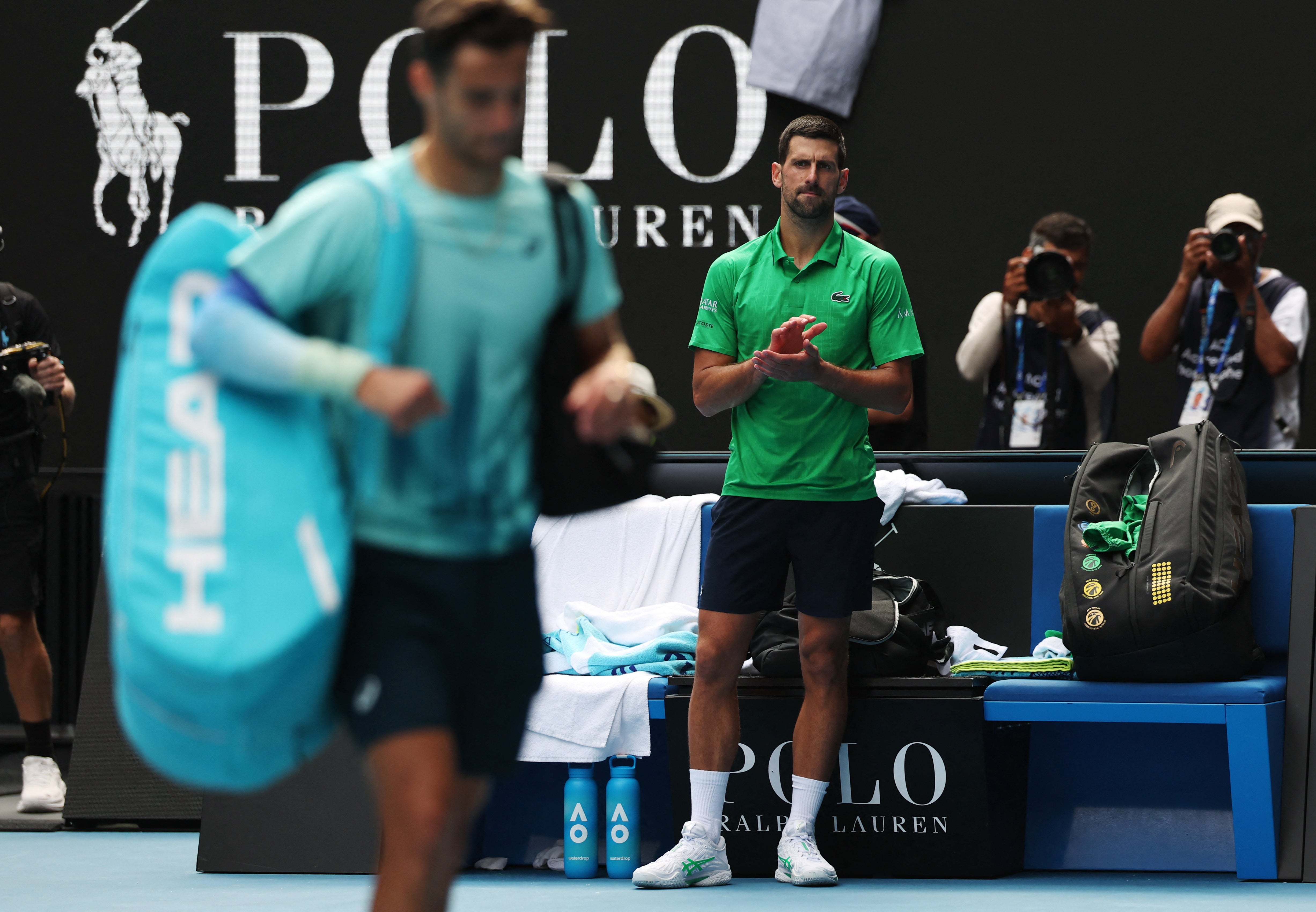 Novak Djokovic applauds the injured Lorenzo Musetti from the court