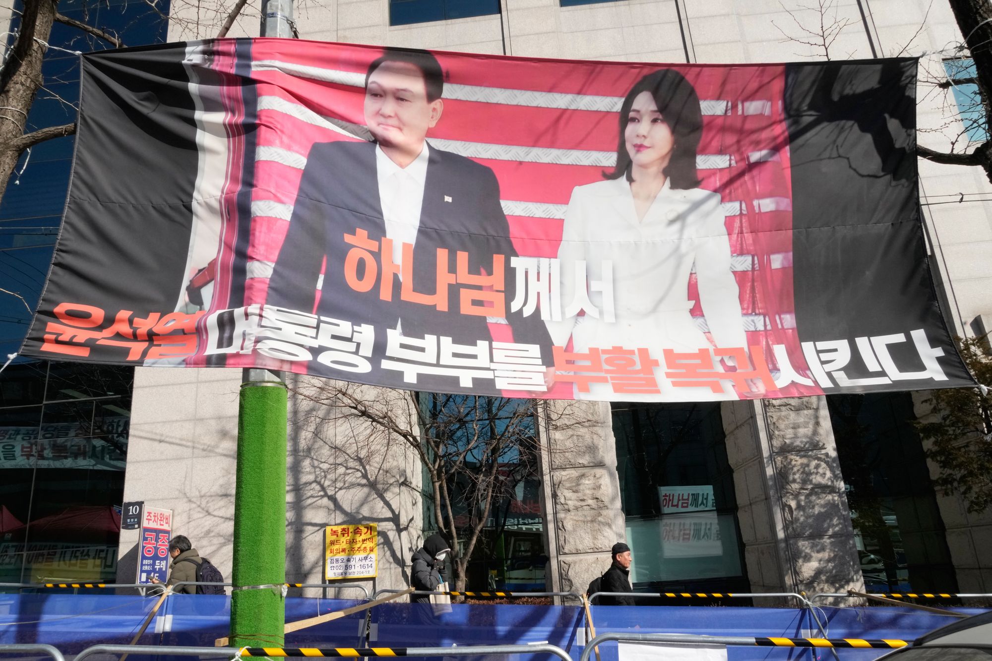 A banner showing the picture of former South Korean President Yoon Suk Yeol and his wife Kim Keon Hee is seen outside Seoul Central District Court in Seoul, South Korea, Wednesday, 28 January 2026. The sign reads: ‘God brings back president Yoon Suk Yeol and his wife’