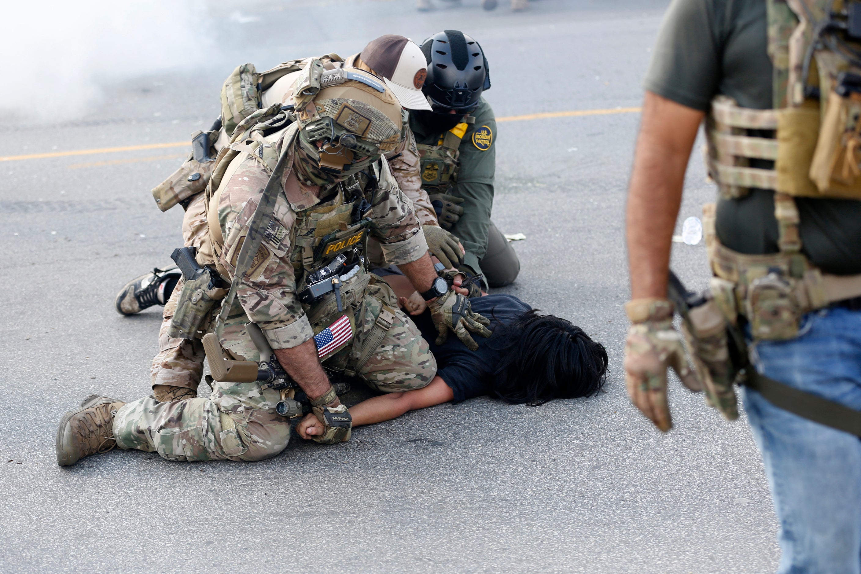 A person is detained as residents of Chicago's Brighton Park neighbourhood confront US Border Patrol and other law enforcement agents at a gas station after Immigration and Customs Enforcement (ICE) agents allegedly detained an unidentified man riding in his car, in Chicago, Illinois, on 4 October 2025