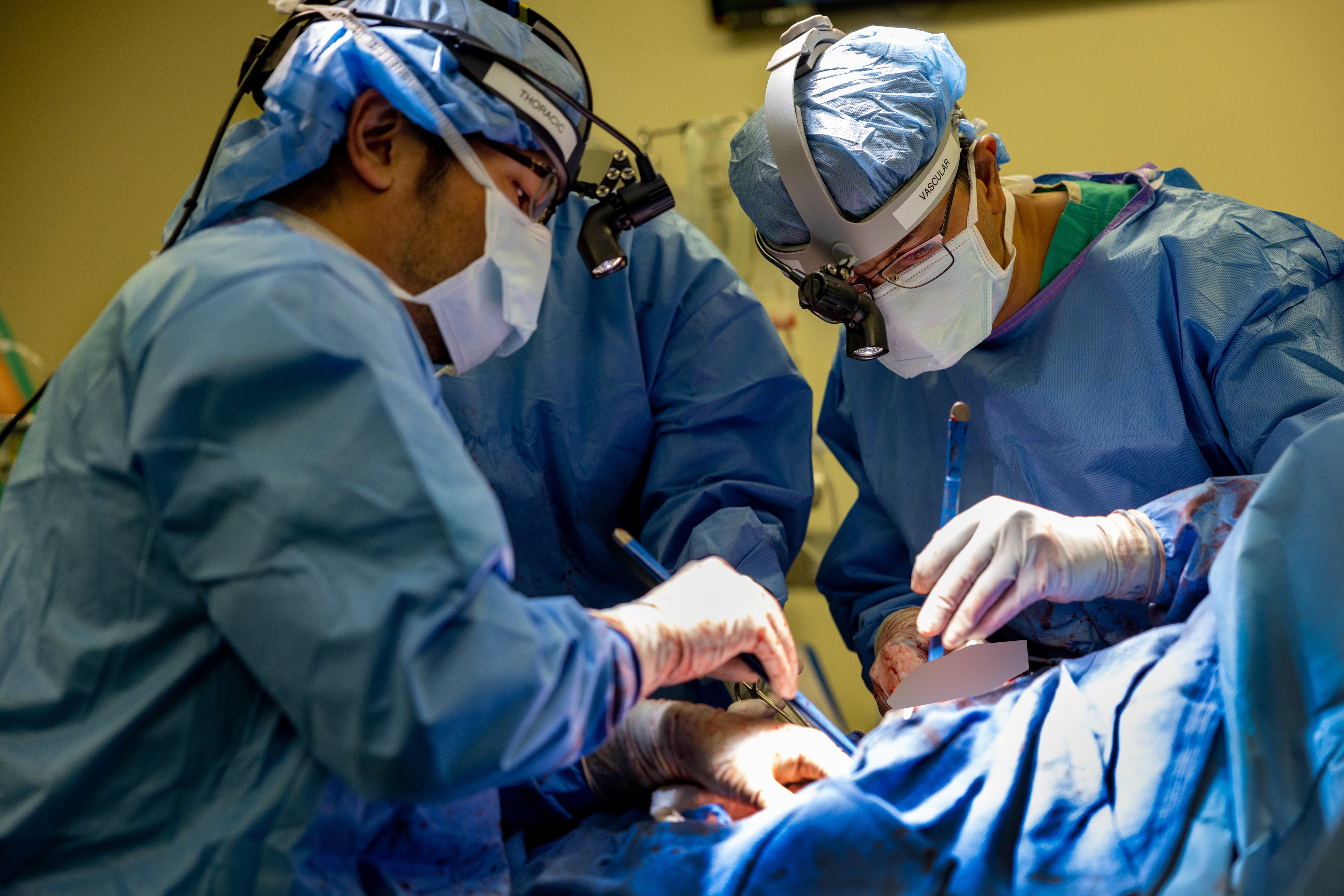 Dr Chitaru Kurihara, left, and Dr Ankit Bharat, right, operating on a patient, removing the damaged lungs and attaching an artificial lung