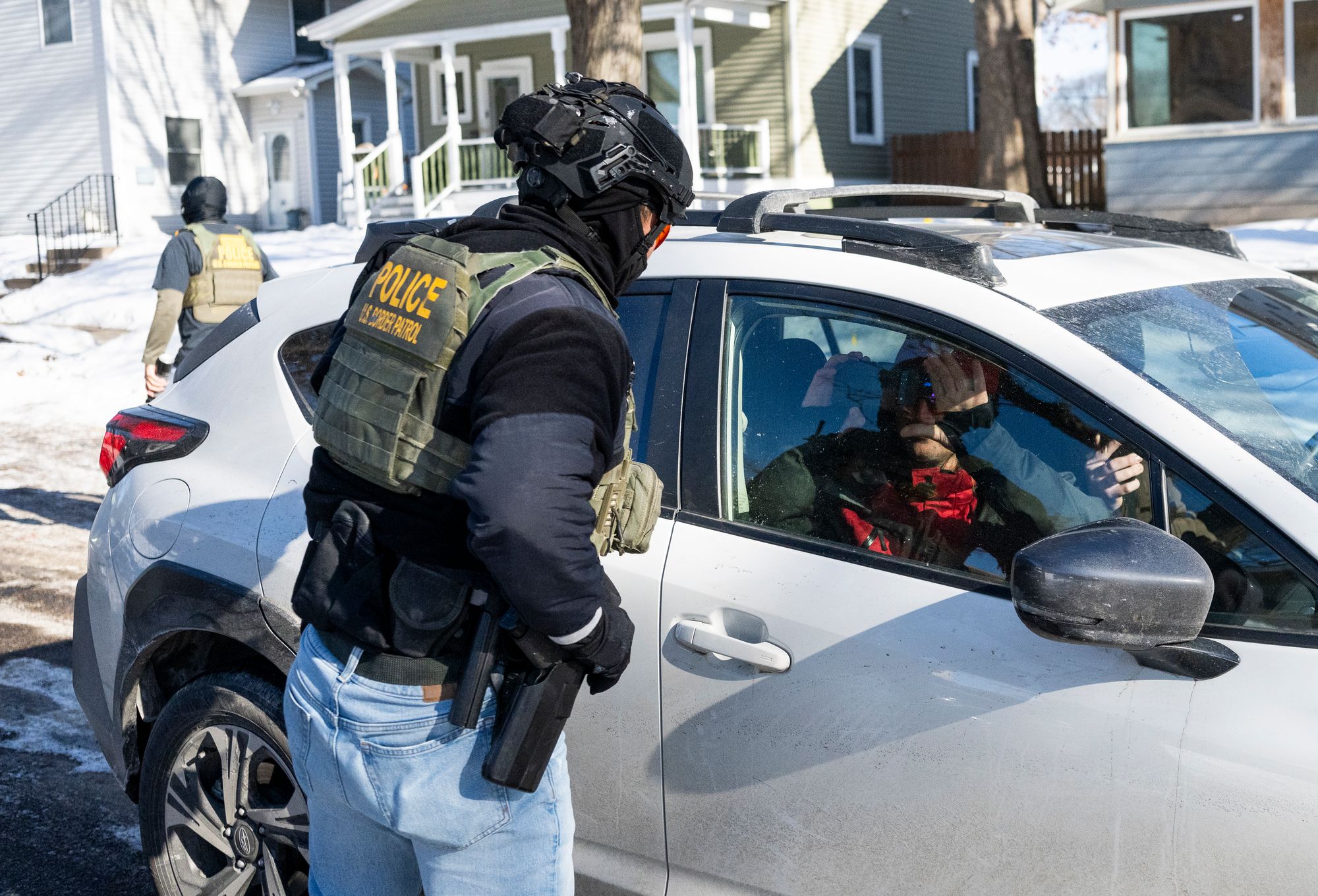 A member of Border Patrol confronts the passenger of a car that was following them