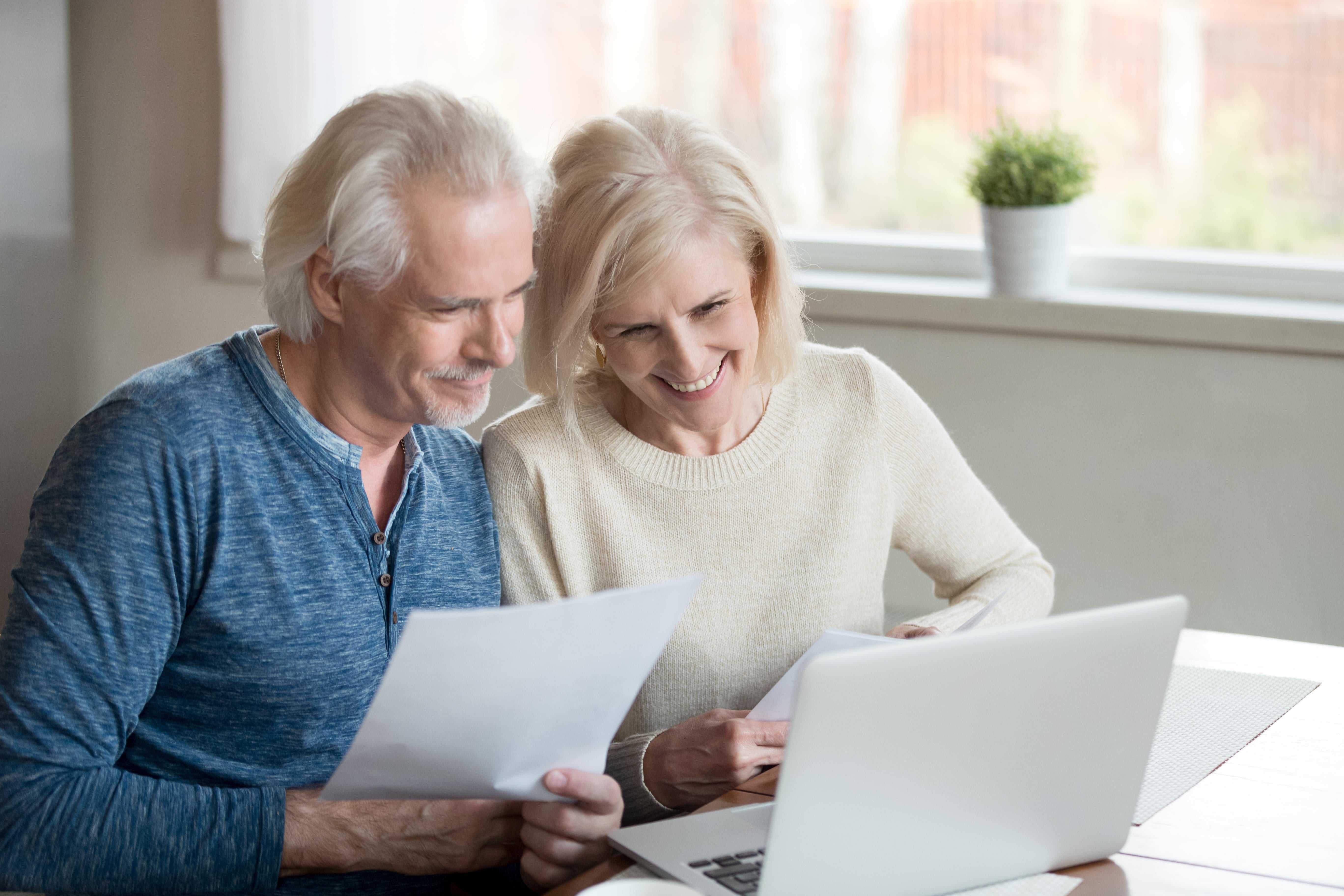 A retired couple looking through bank statements together