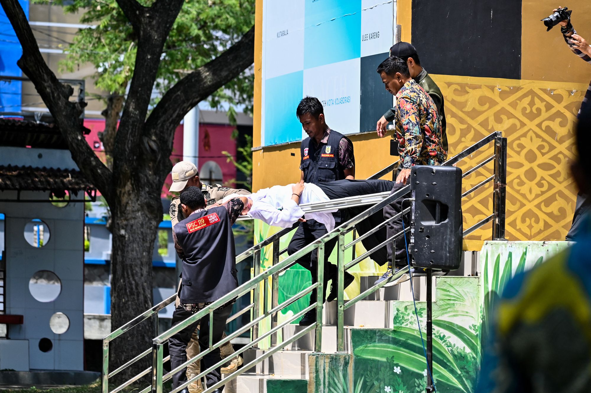 A medical team and Sharia police members carry a woman who fainted after being publicly caned by a member of the Sharia police in Banda Aceh on 29 January 2026