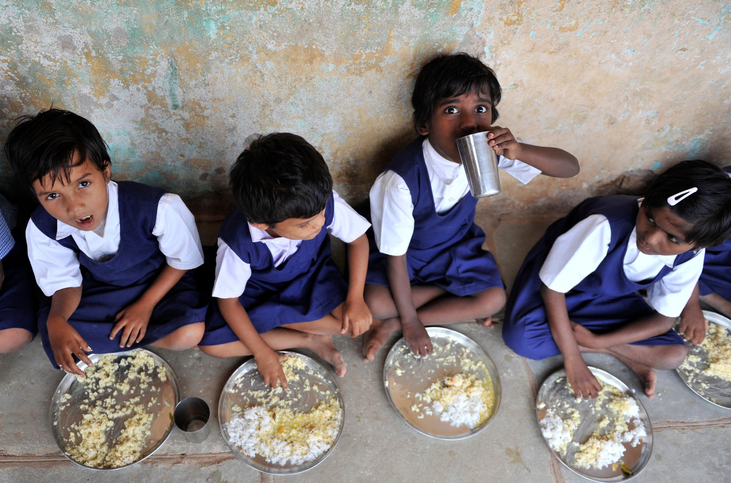 <p>File. Children eat food served  under the midday meal scheme at a government primary school in Hyderabad </p>