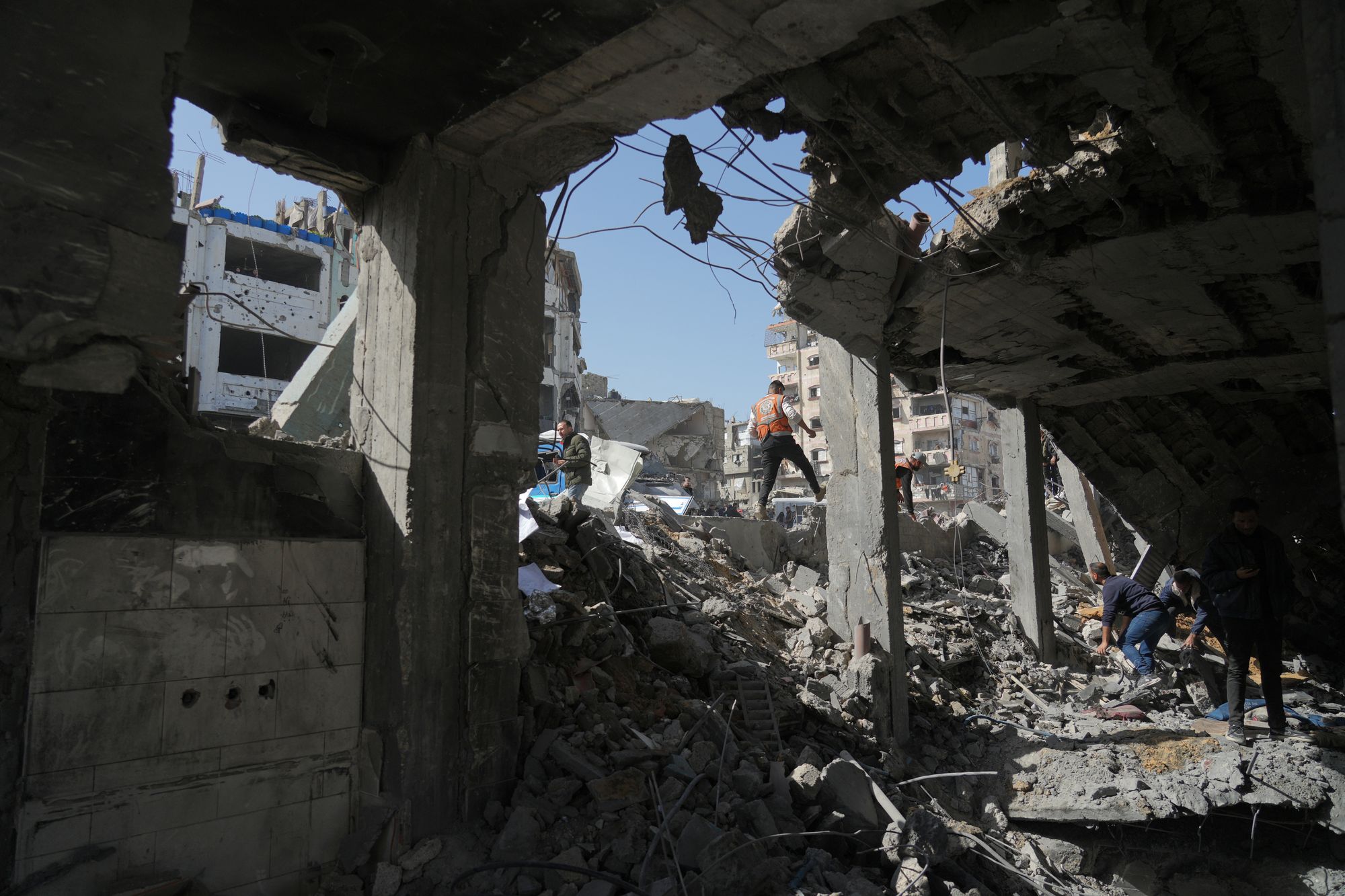Palestinians search for bodies and survivors from the rubble of a police station in Gaza City