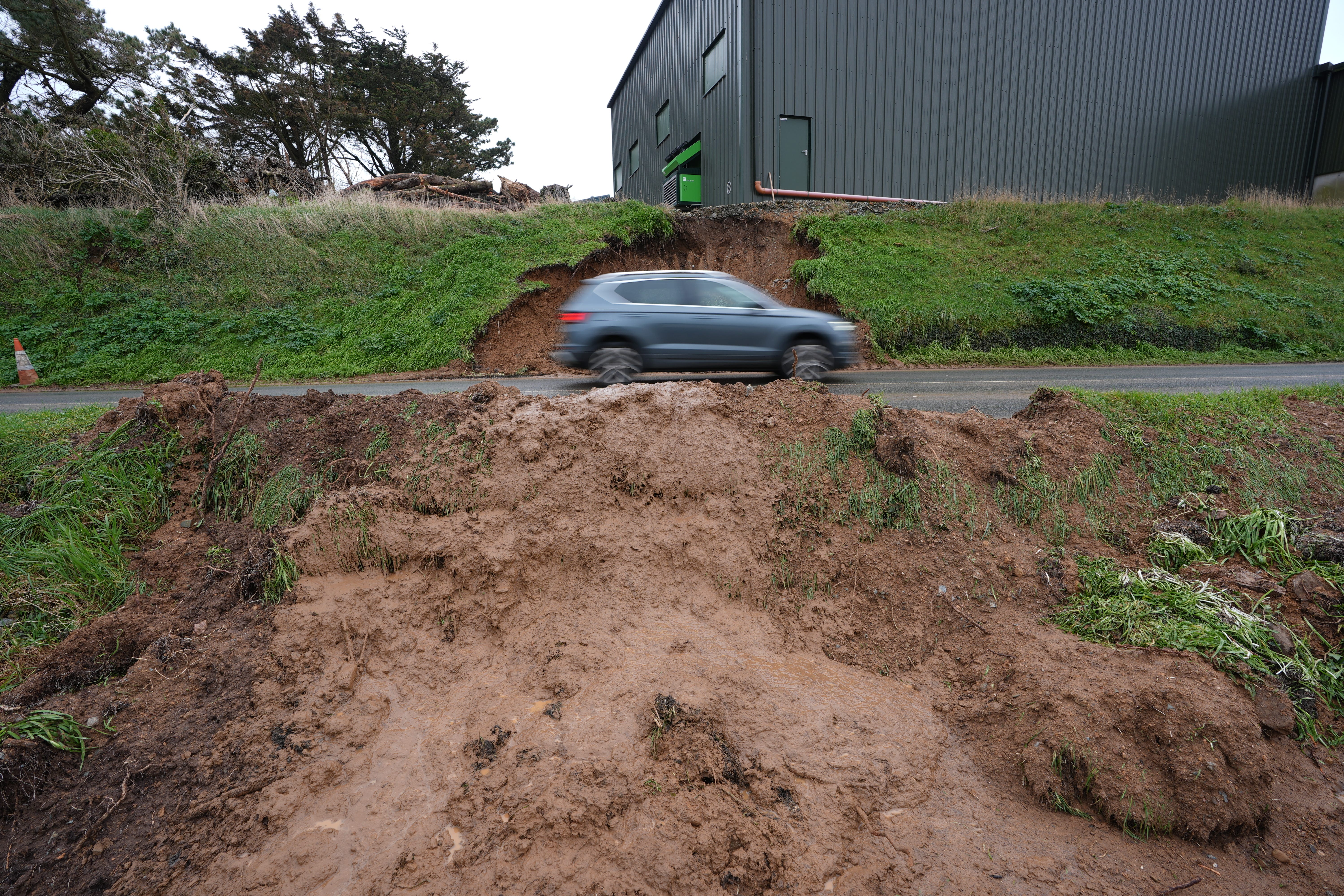 A car passes the scene of a landslide caused by heavy rain at Lady’s Island in Co Wexford (Niall Carson/PA)