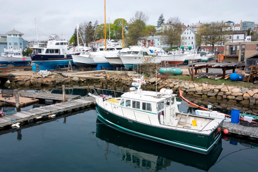 Boats in Gloucester Harbor. The Coast Guard recovered one body from a sunken Massachusetts fishing vessel, while six others remain missing after the search was suspended