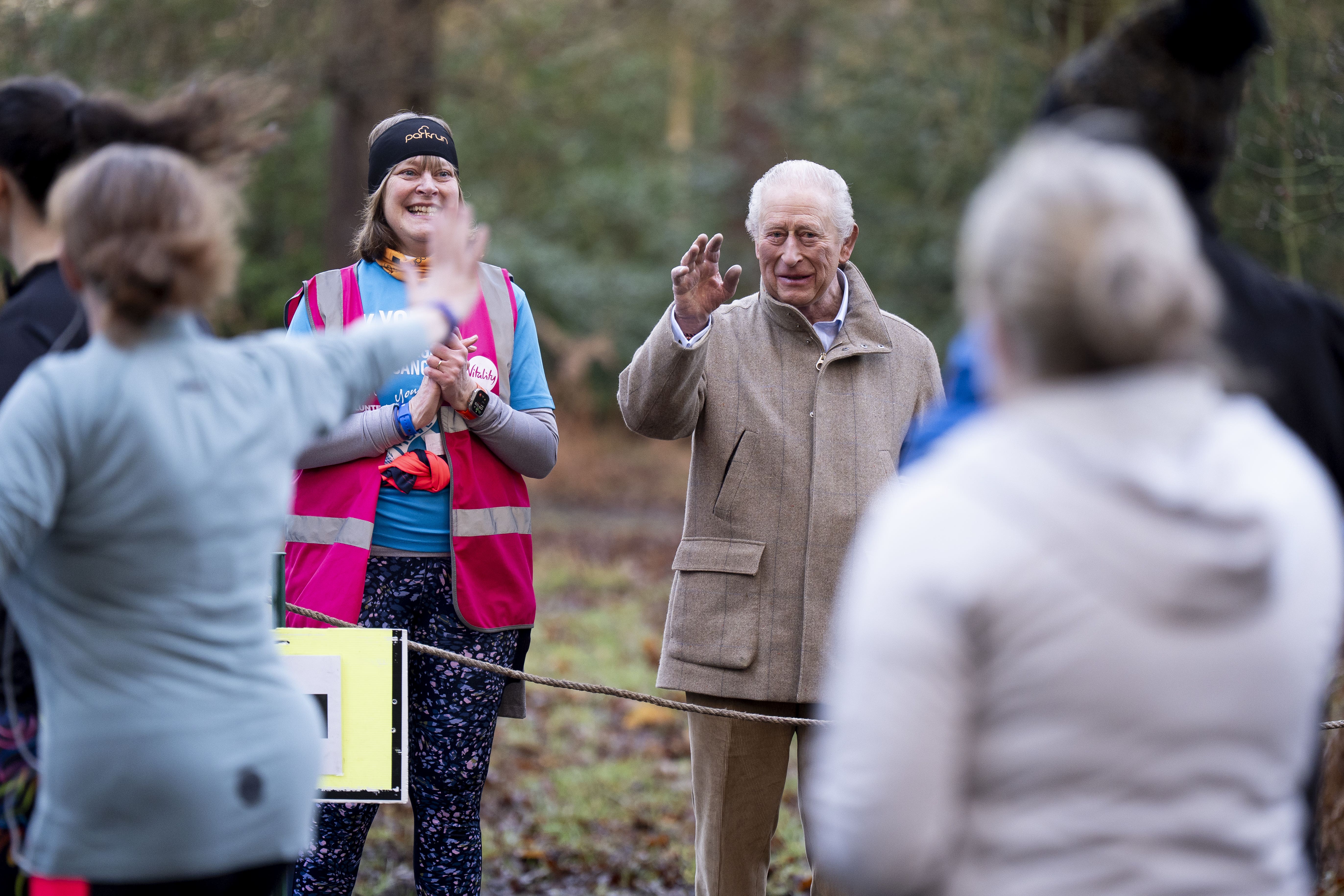 Charles waves to runners from a marshal point at Sandringham (Aaron Chown/PA)