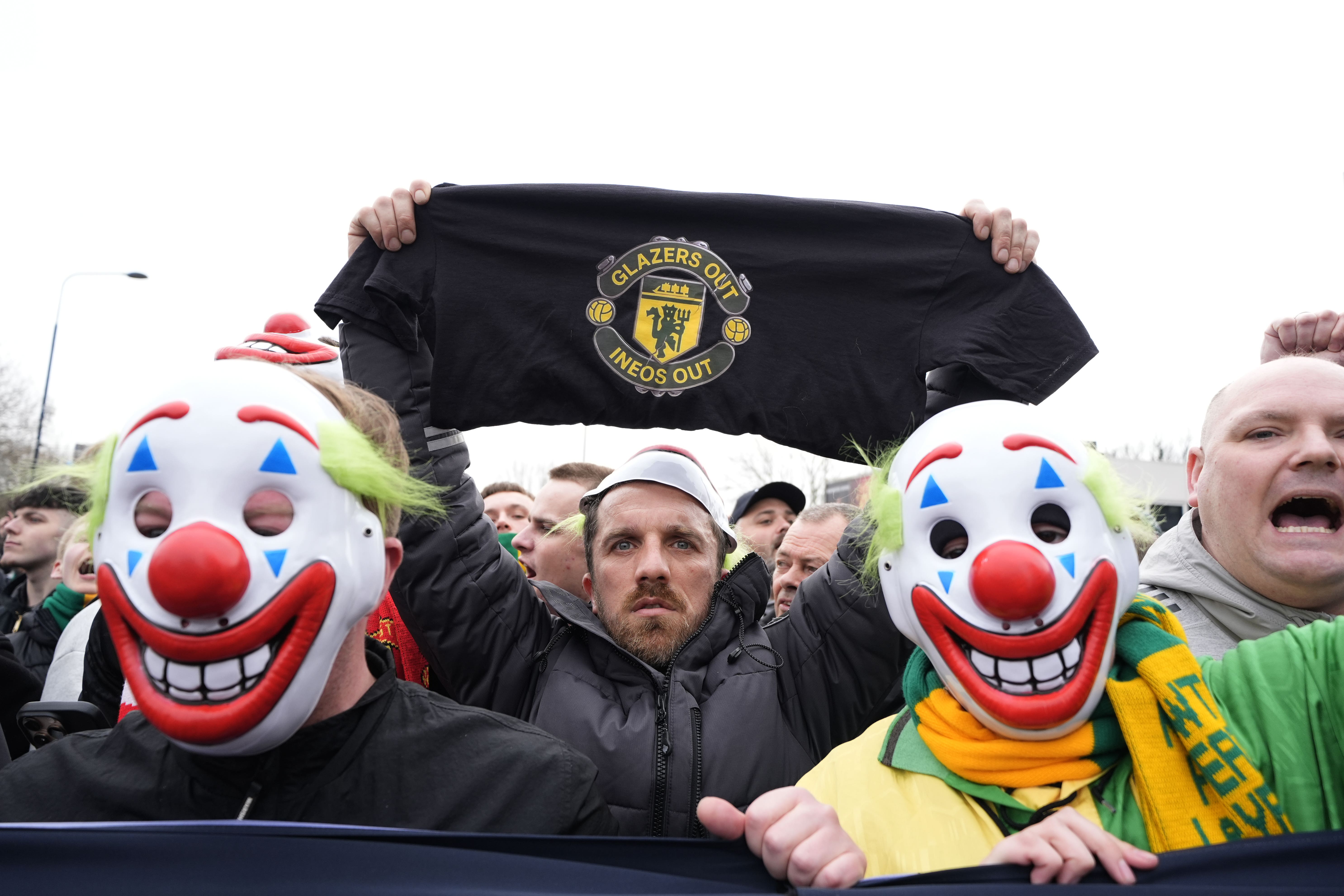Manchester United fans wore clown masks holding banners during the pre-match protest (Peter Byrne/PA)